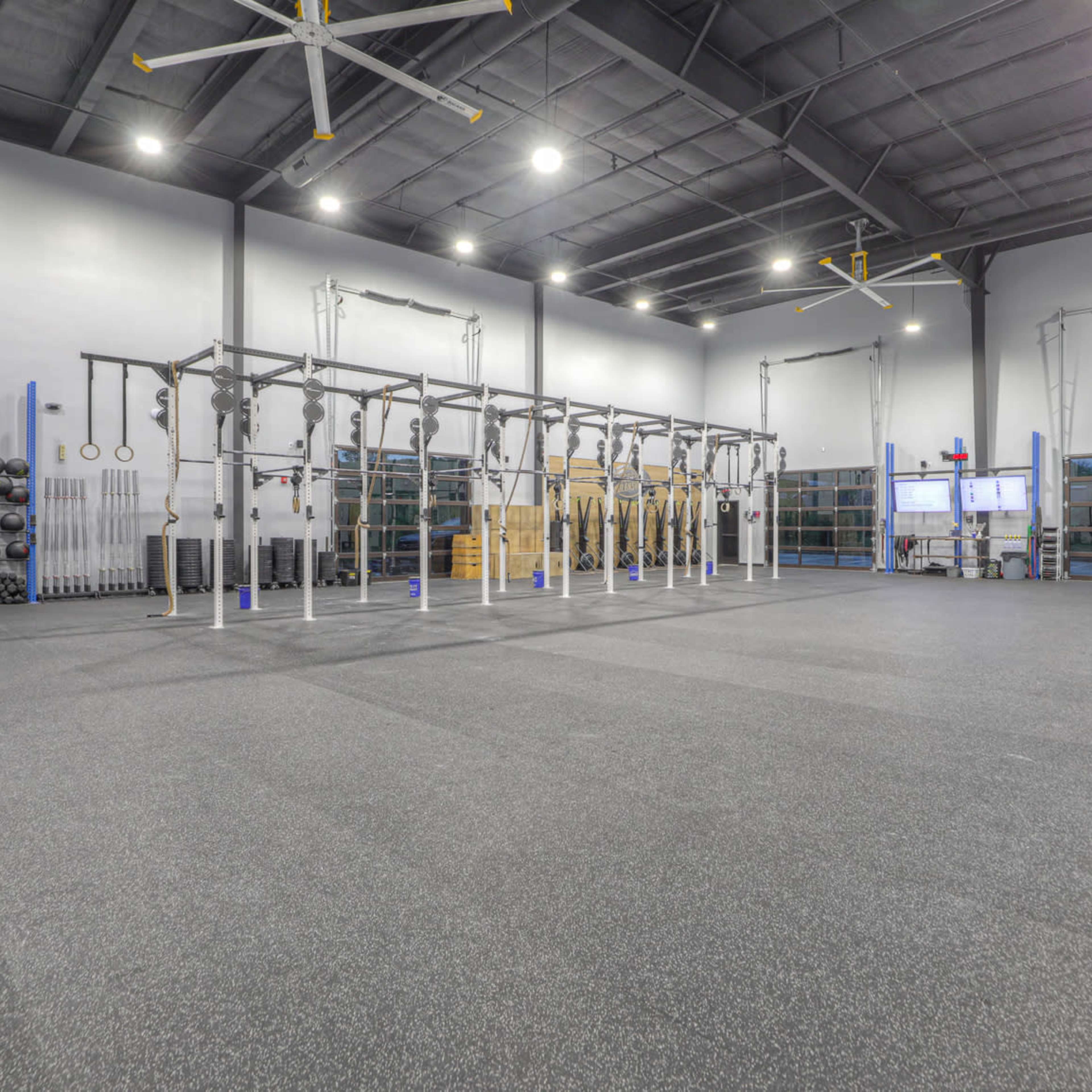 An indoor gym with various exercise equipment, including free weights and a multi-functional rig for workouts.