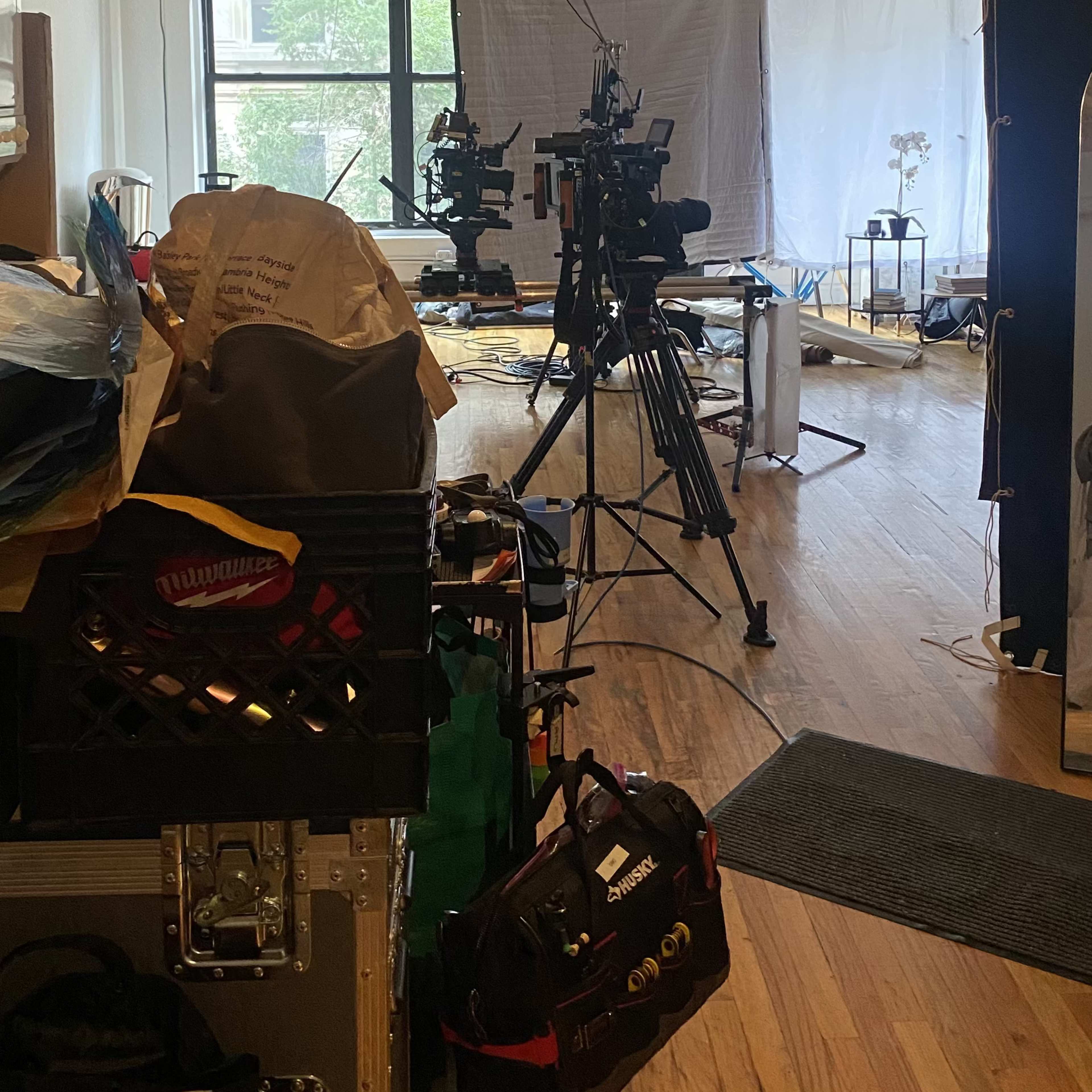 A well-lit studio space set up for filming, with cameras, lights, and various equipment scattered around.