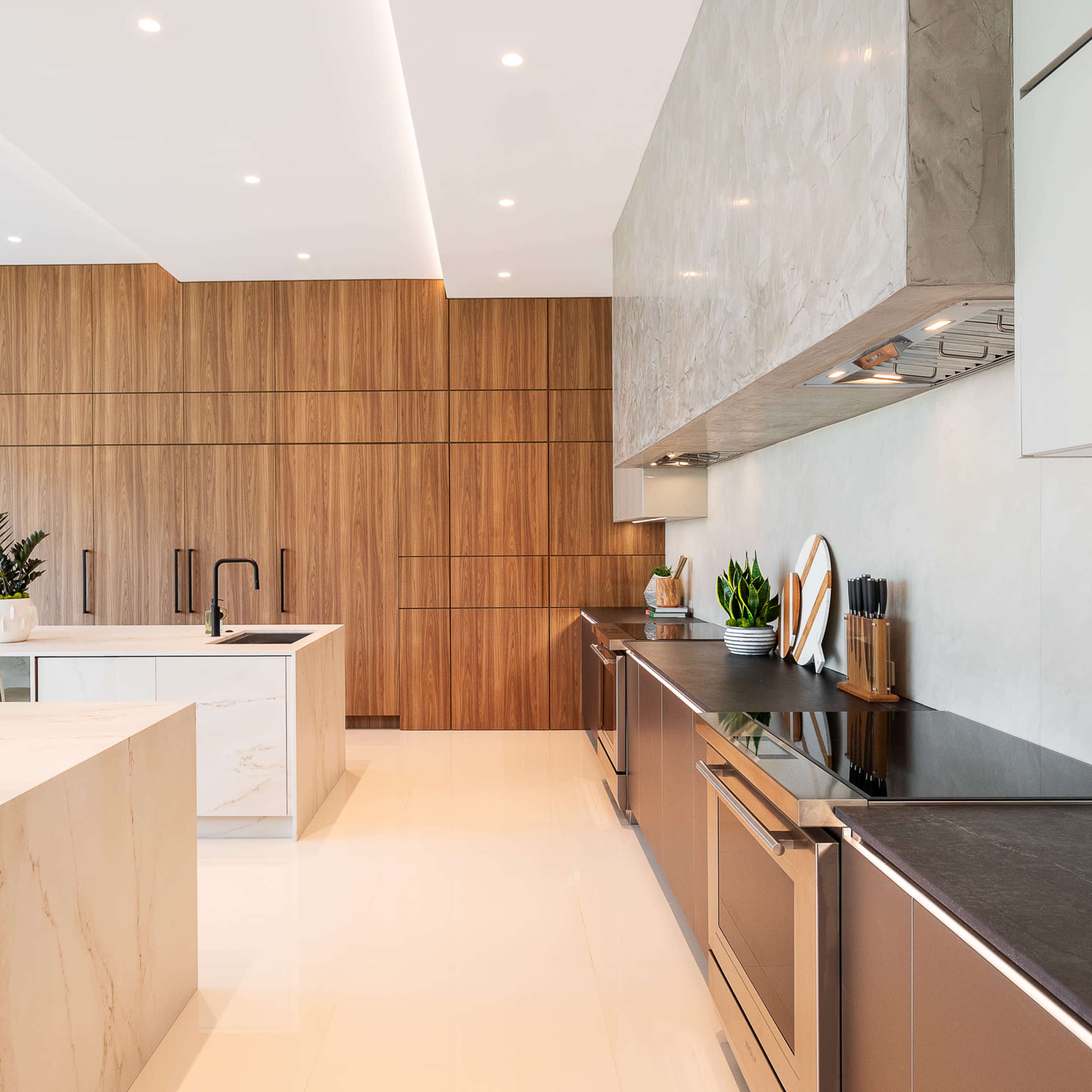 The kitchen features a sleek design with a large island, wooden cabinetry, and modern stainless steel appliances.