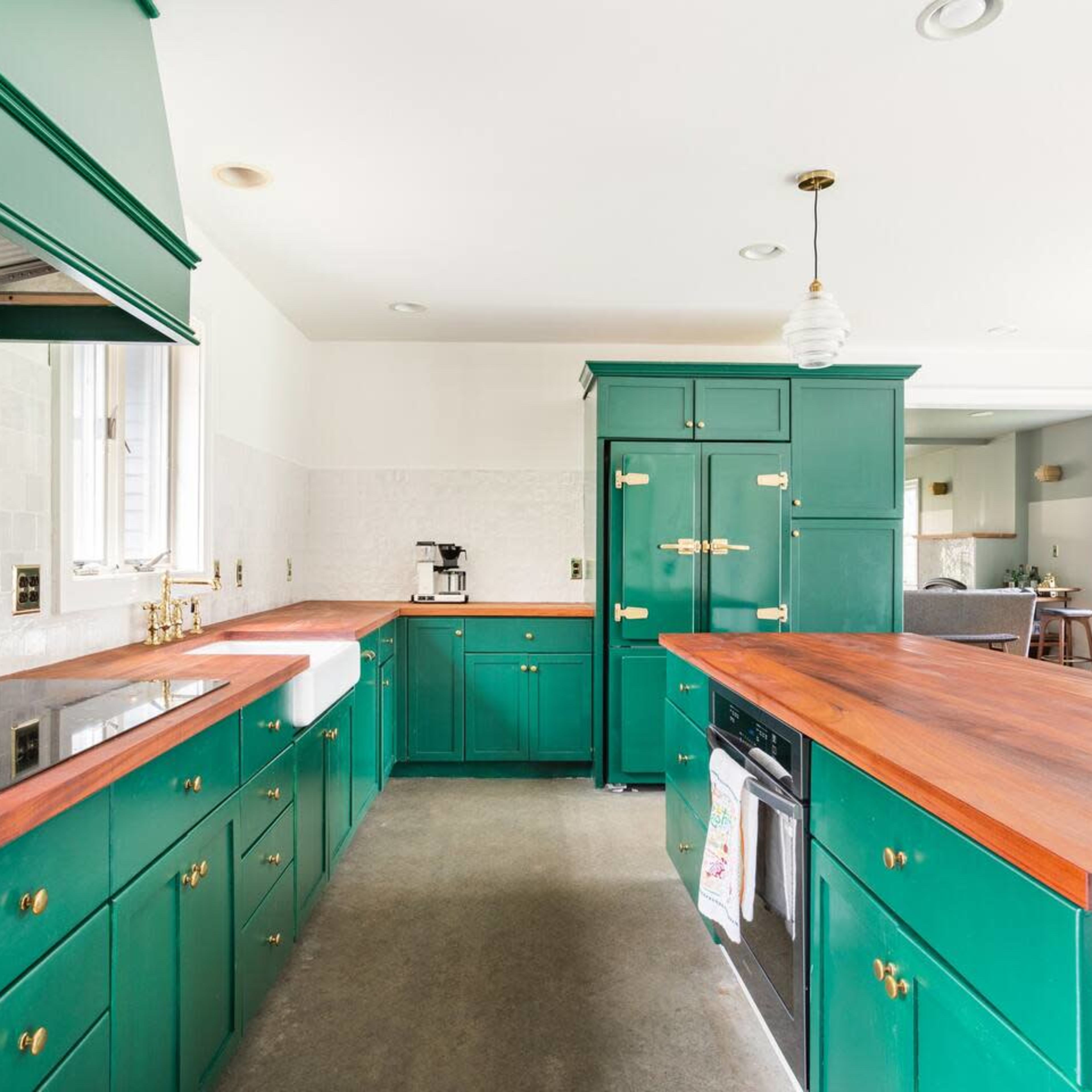 The kitchen features green cabinetry, wooden countertops, and modern appliances with an open layout.