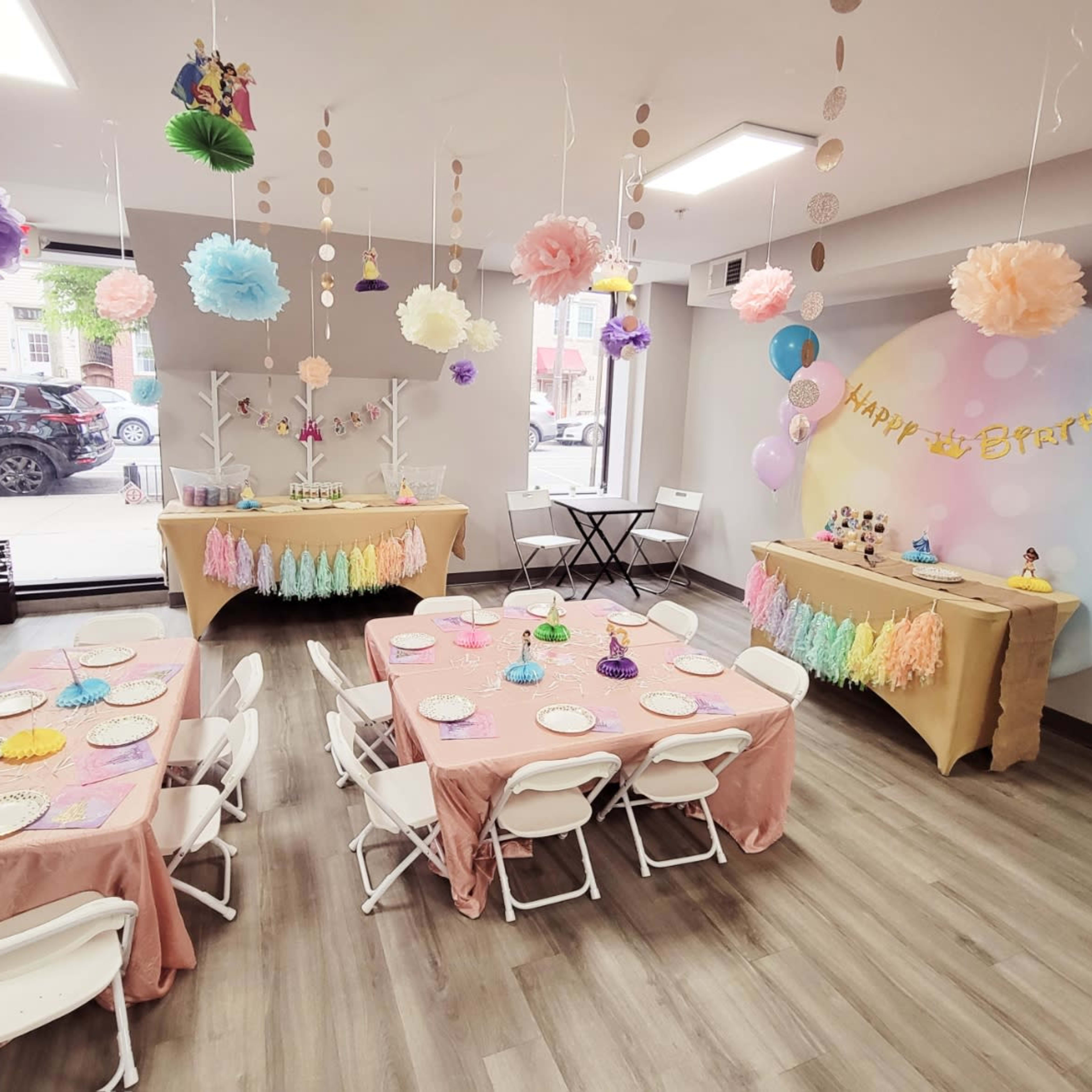 A decorated party room with tables set for a birthday celebration, featuring colorful decorations and themed items.