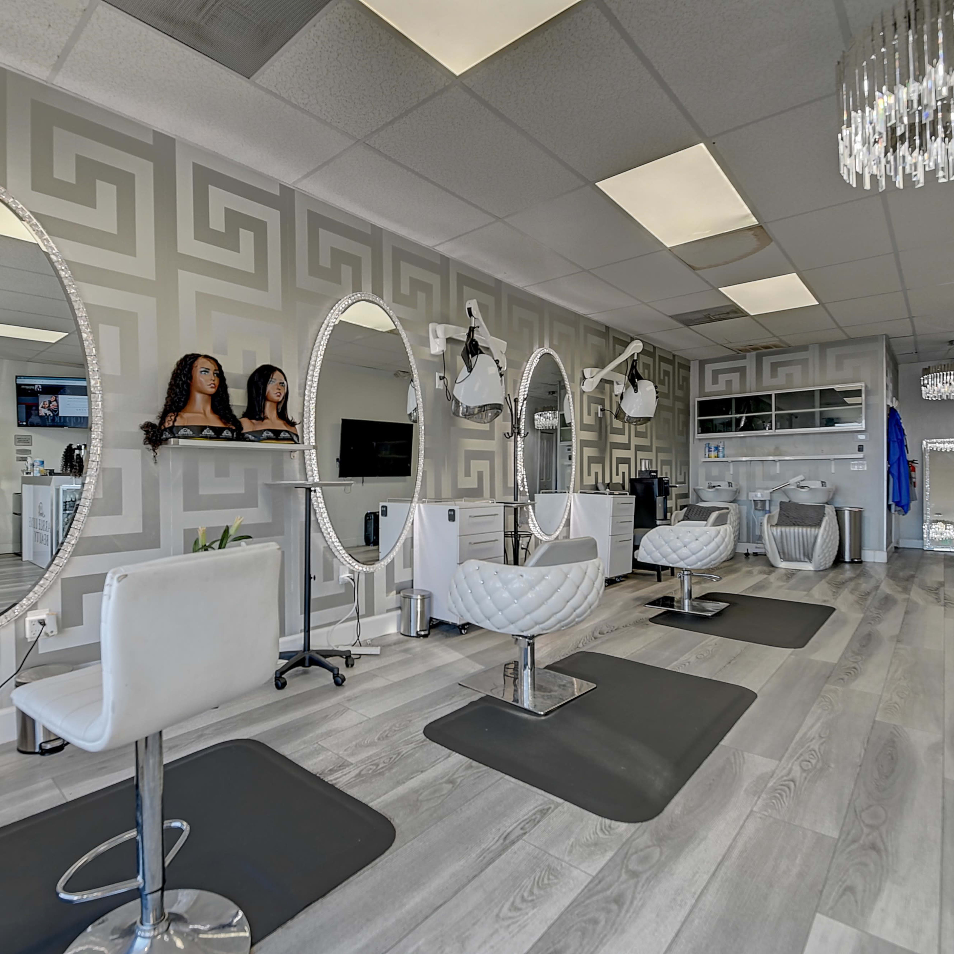 A hair salon interior featuring multiple styling stations with round mirrors, modern chairs, and decorative wall patterns.