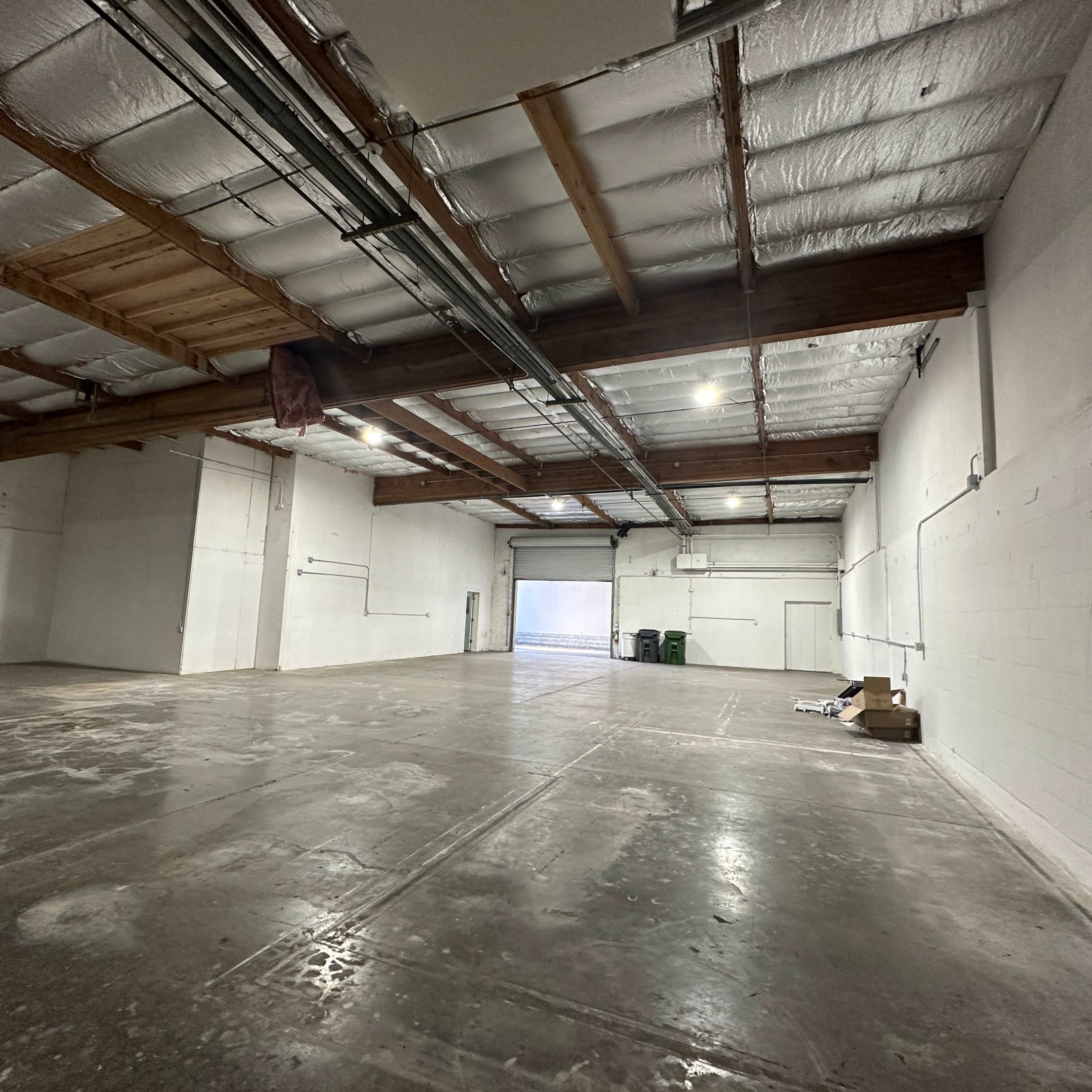 A large, empty warehouse space with concrete floors and exposed beams.