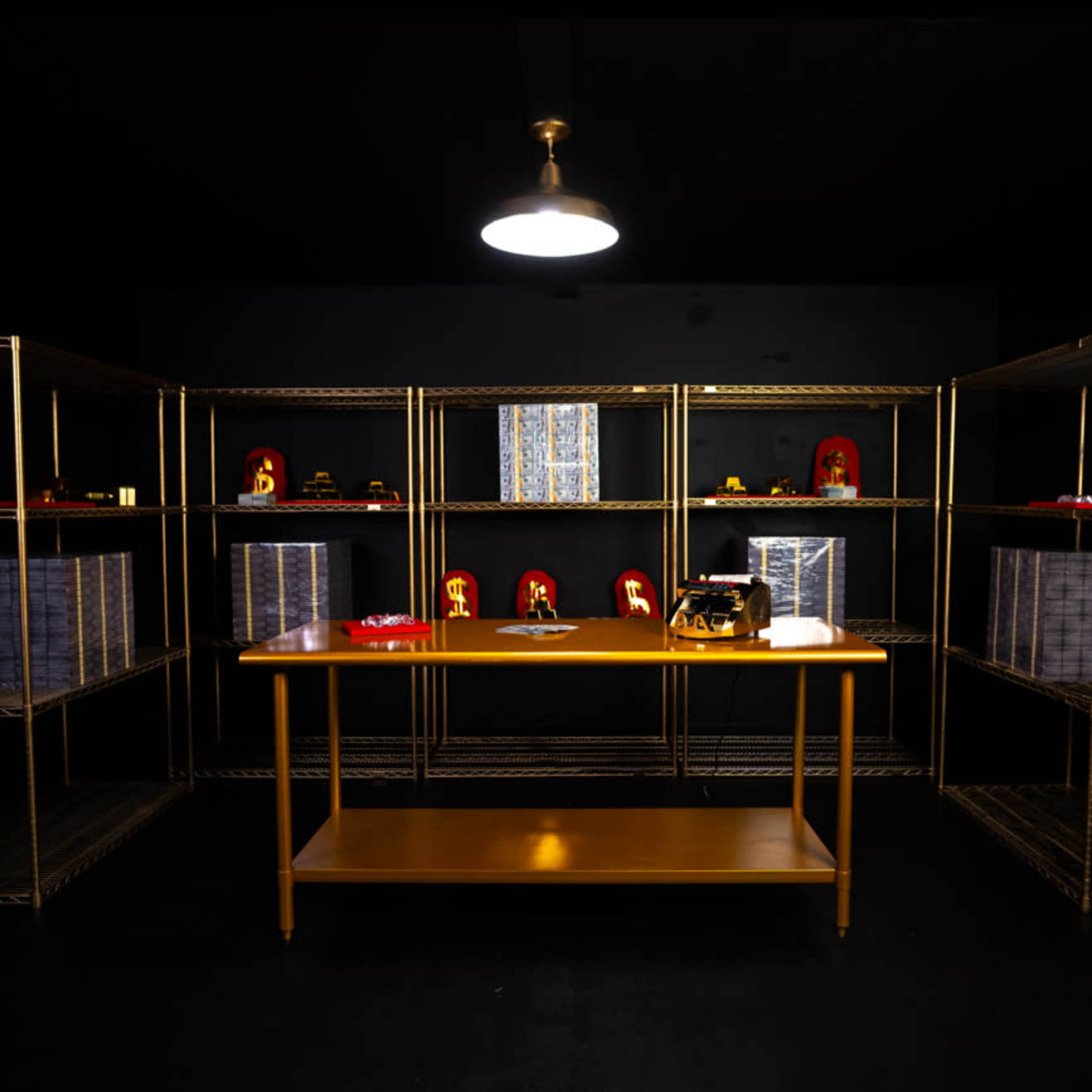 A dimly lit room with gold metal shelves displaying various items, including toys and boxes, arranged around a central wooden table.