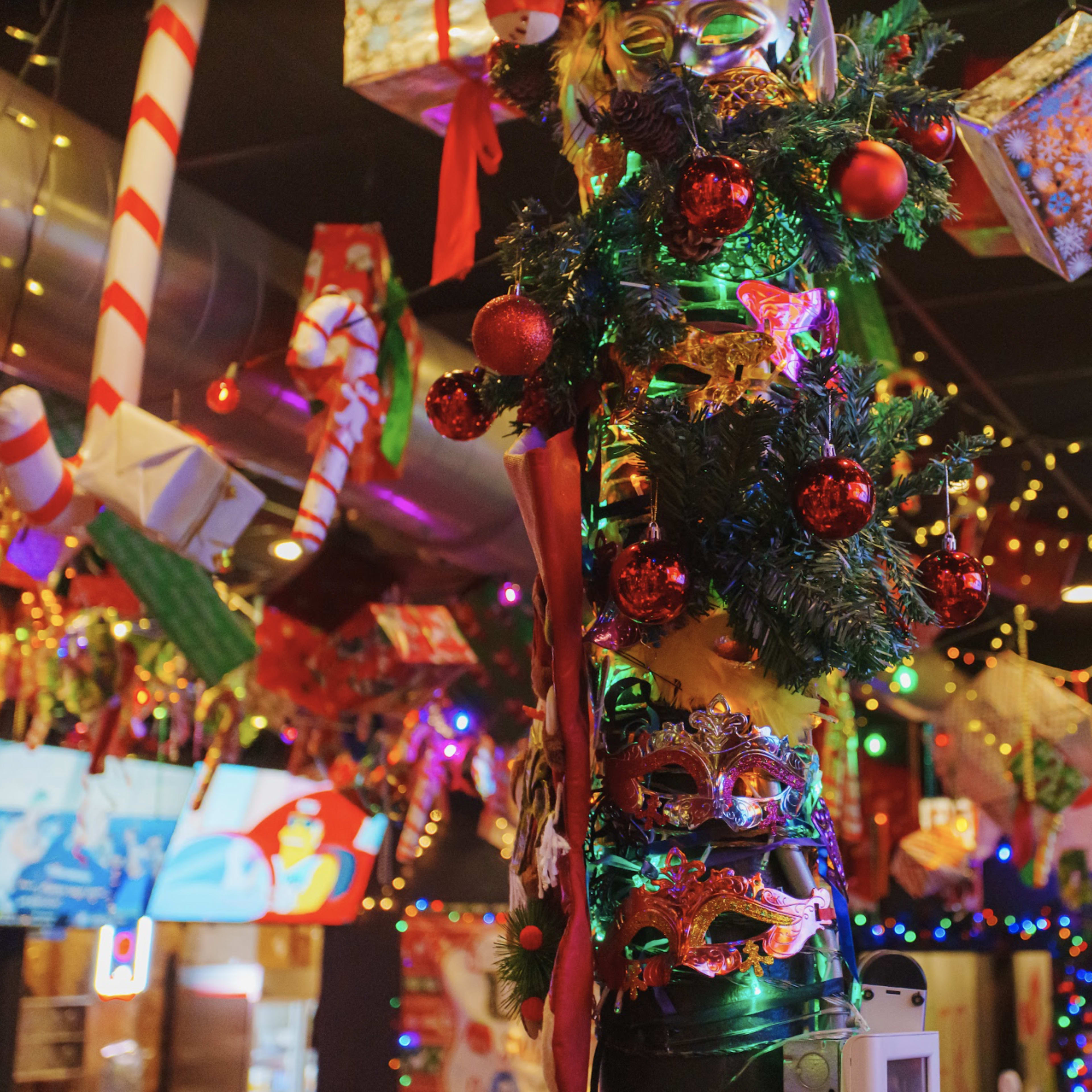 A decorated interior filled with colorful ornaments, garlands, and holiday gifts hanging from the ceiling.