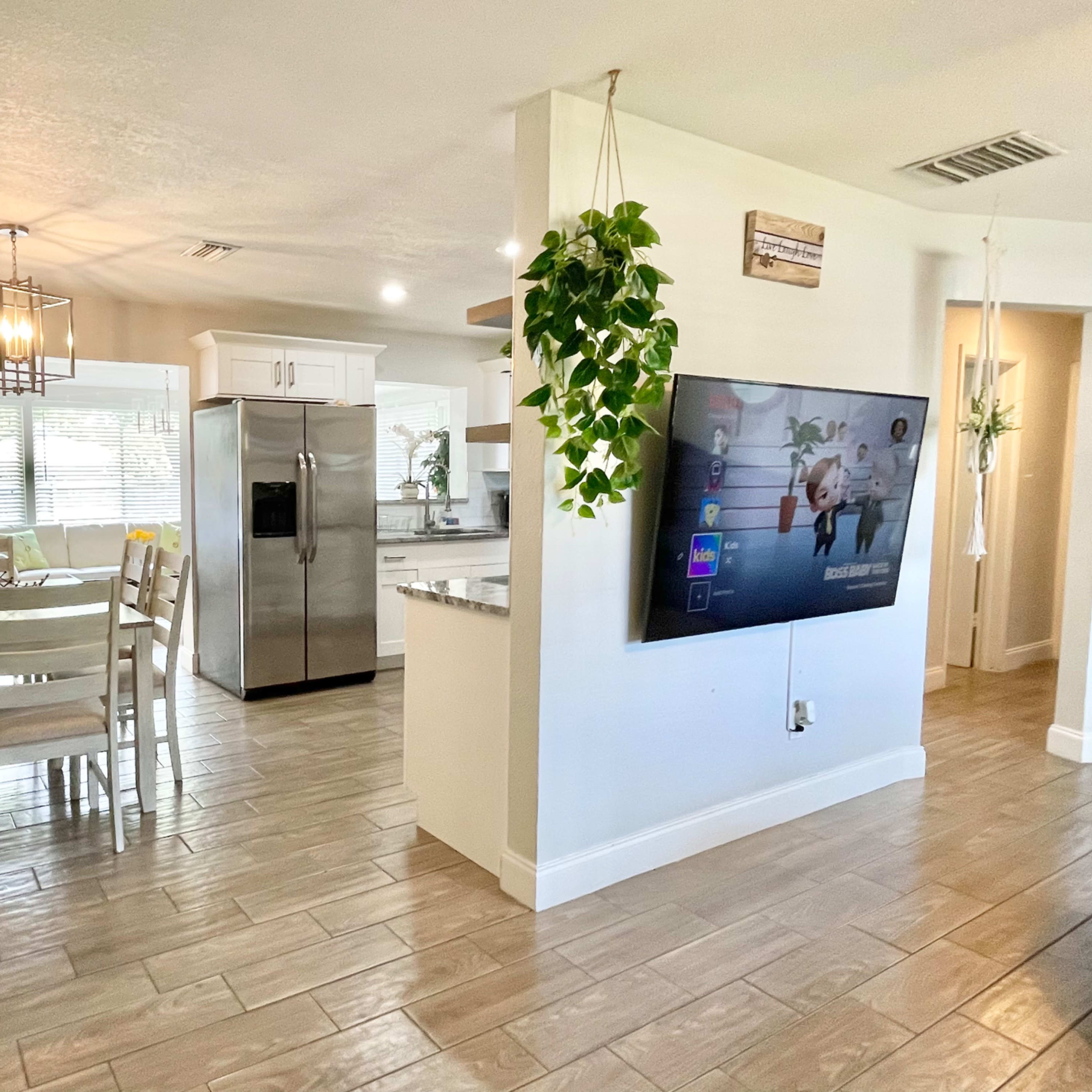 A modern kitchen and dining area with a table set for four and large windows providing natural light.