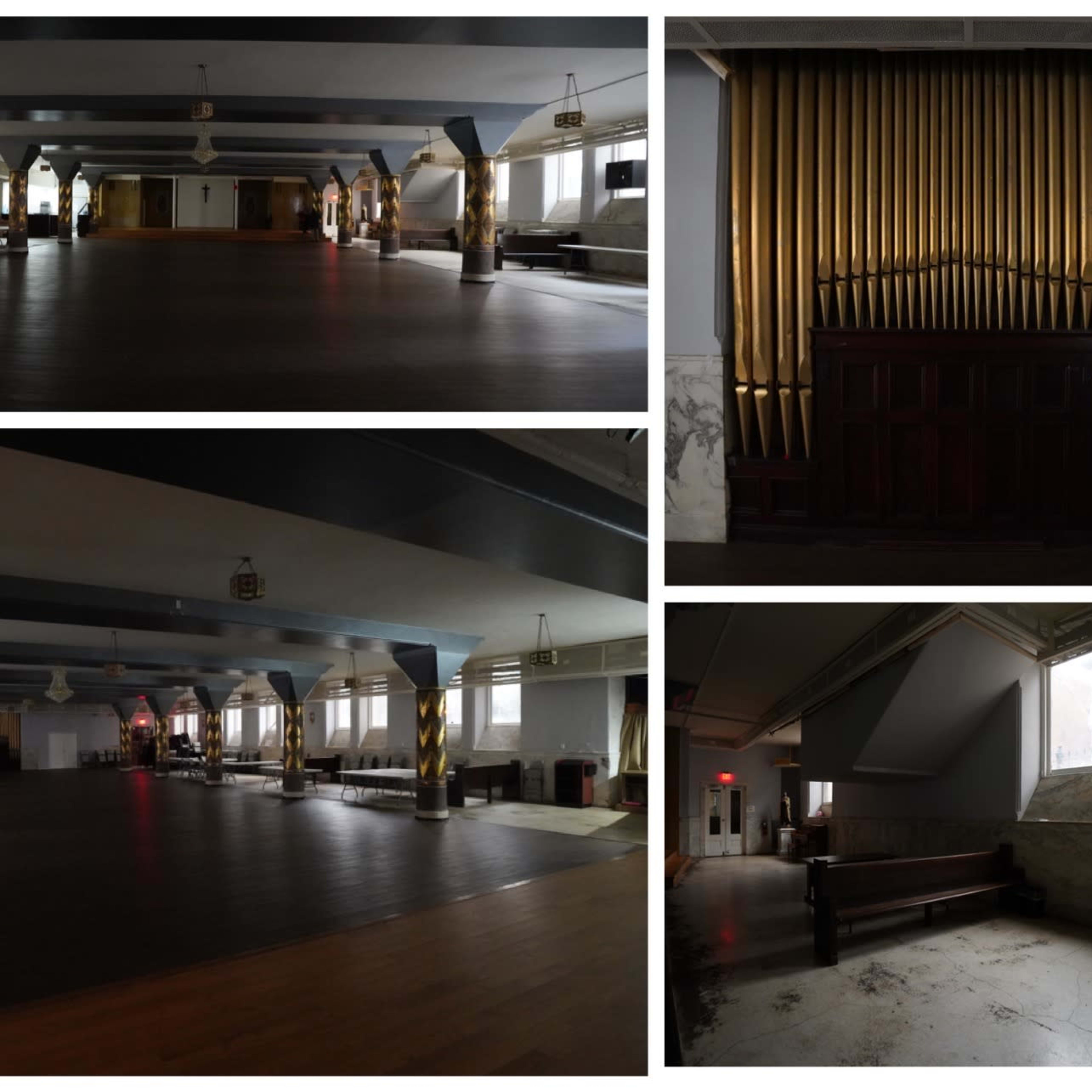 A large, dimly lit hall with polished wooden floors, featuring an ornate pipe organ on one wall and empty spaces arranged with benches and tables.