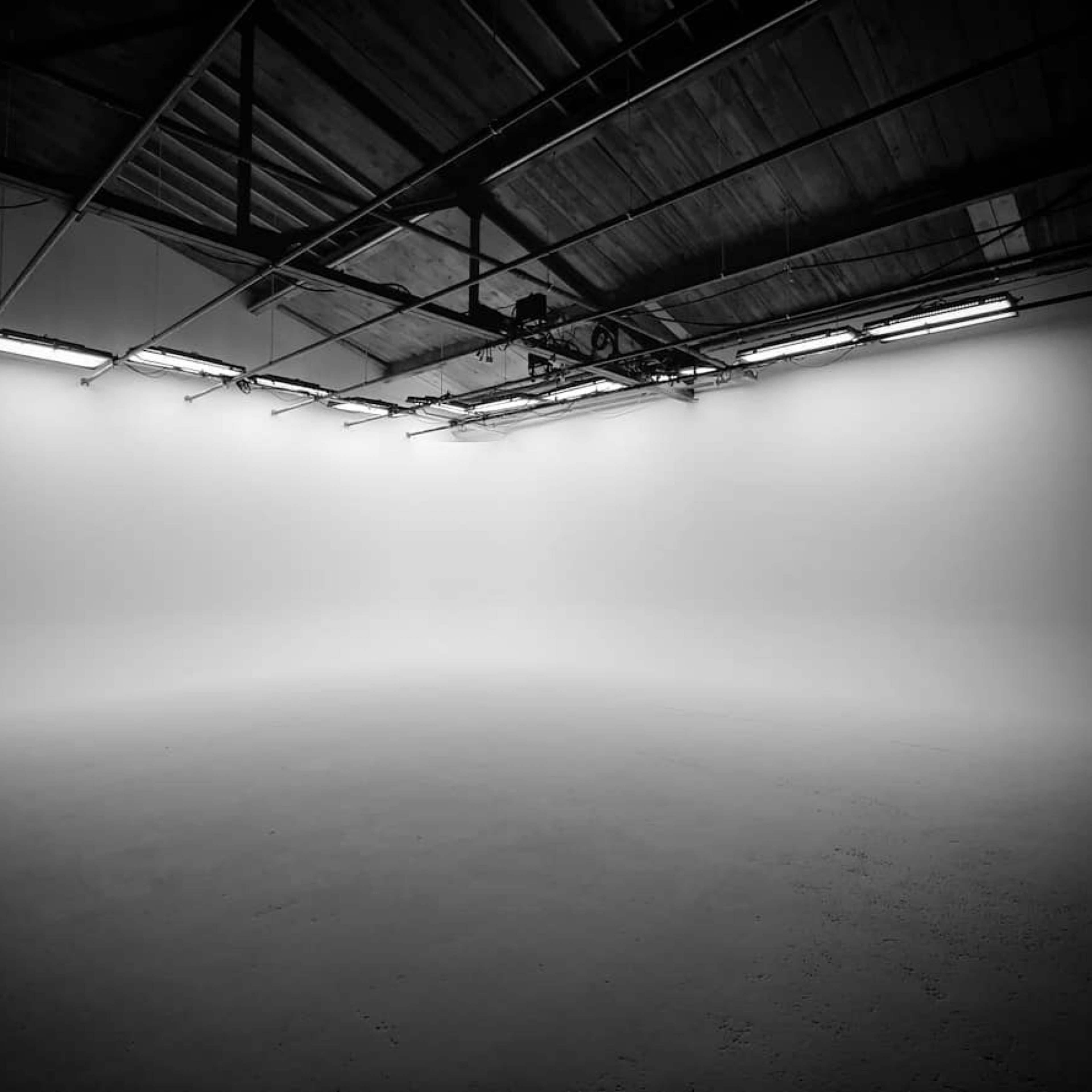 An empty, well-lit studio space with a smooth, blank wall.