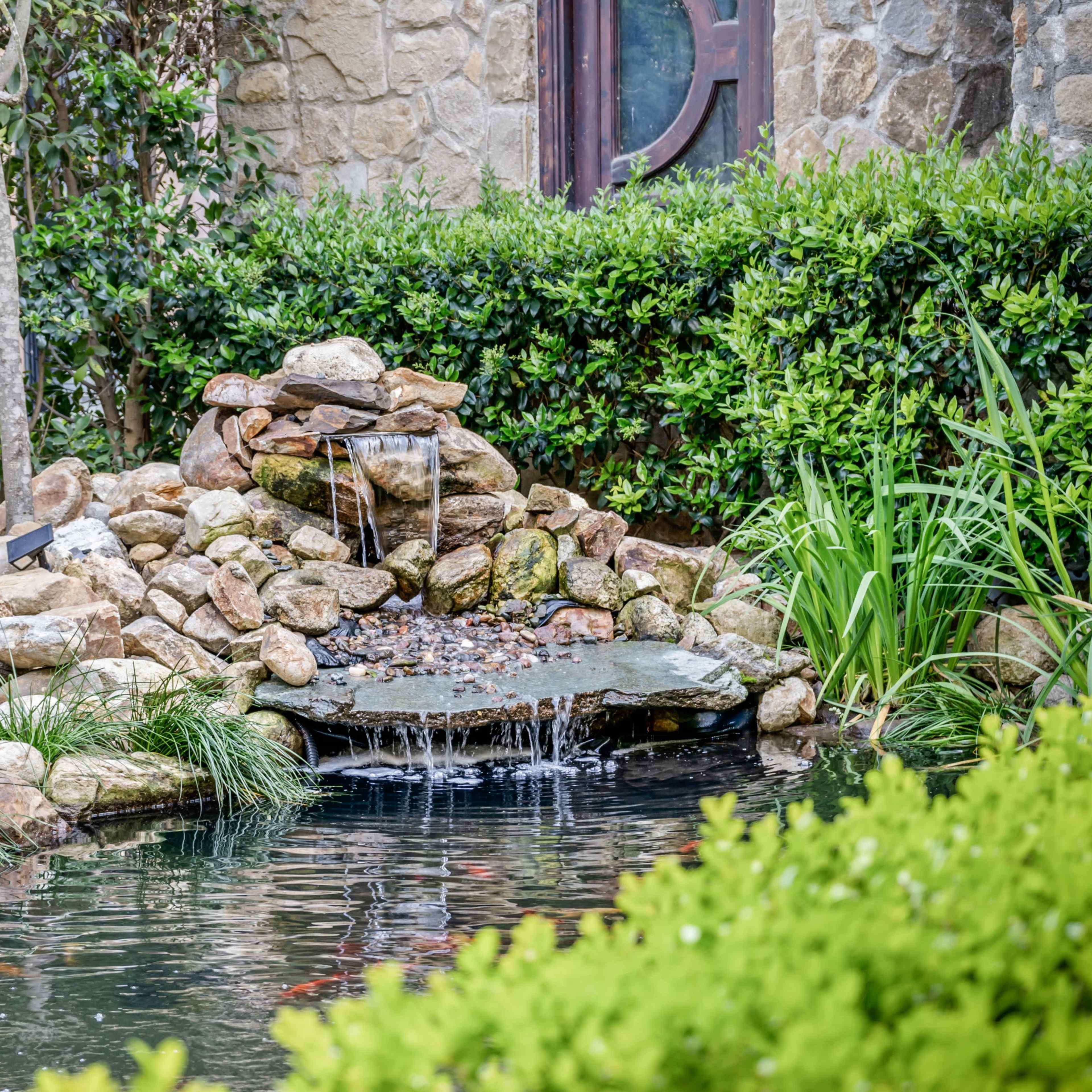 A luxurious estate featuring a grand exterior, elegant interior spaces with modern furnishings, and serene outdoor landscapes surrounding a pond.