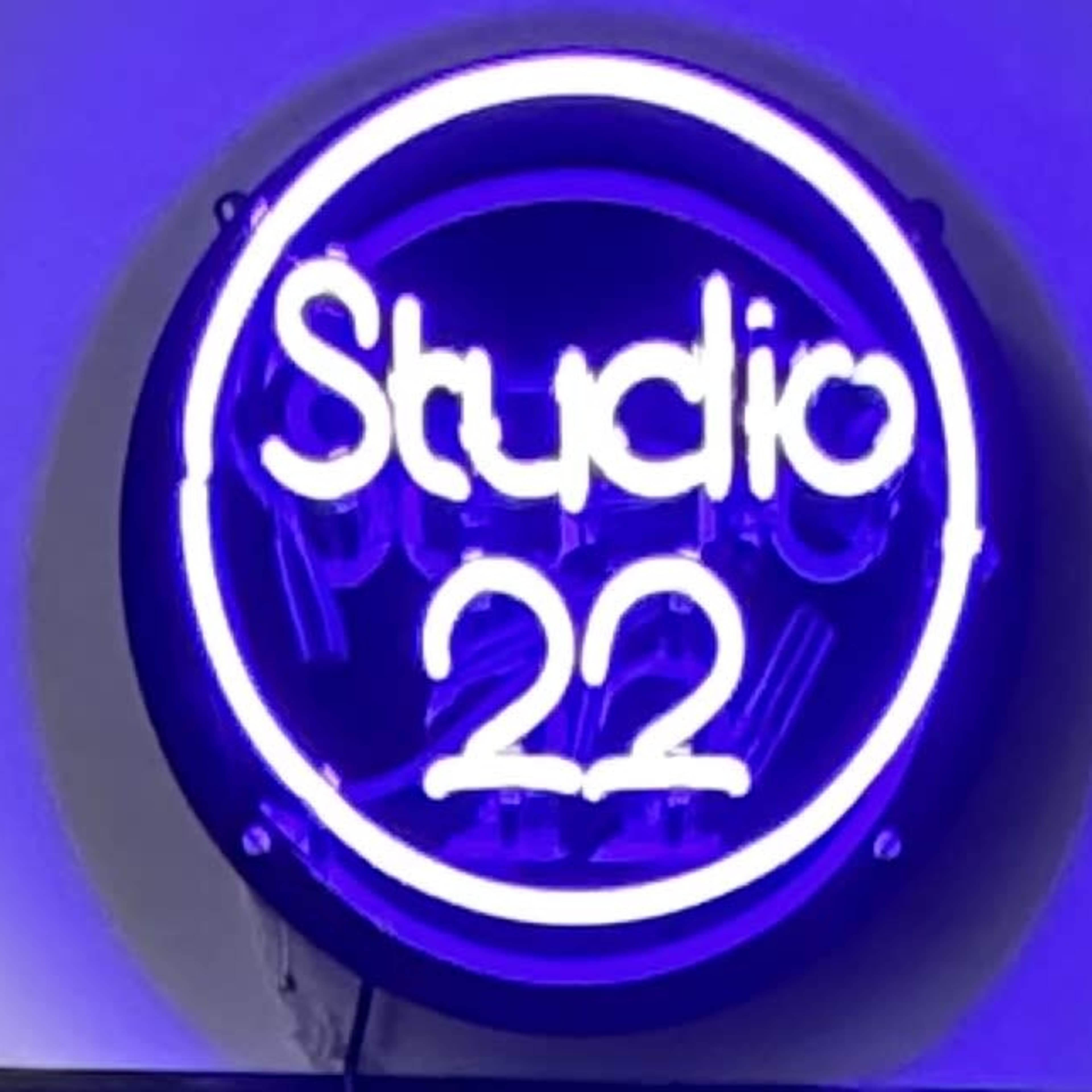 A neon sign displaying the words "Studio 22" in glowing white letters against a purple background.