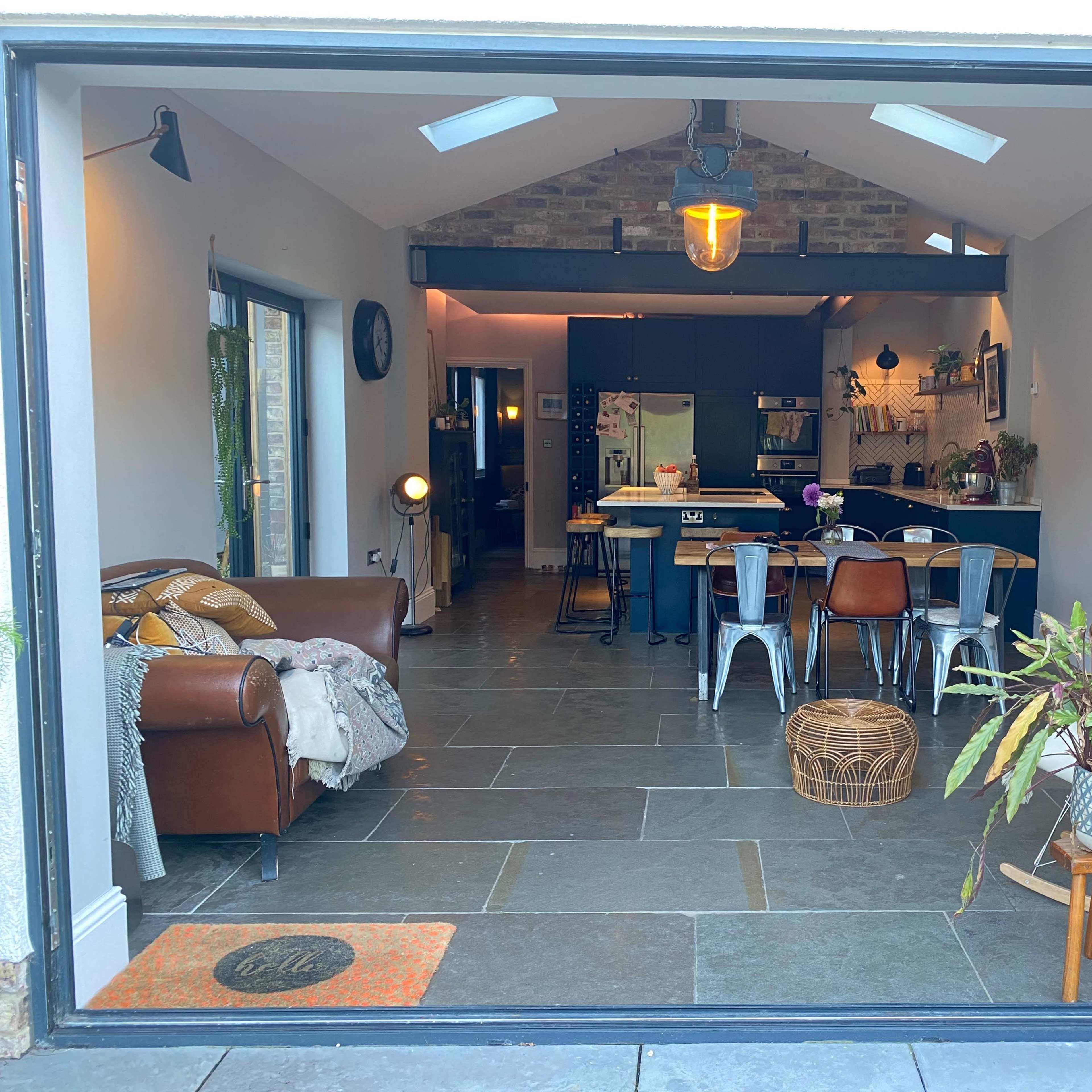 An open-concept living area with a modern kitchen and dining space, framed by large glass doors.