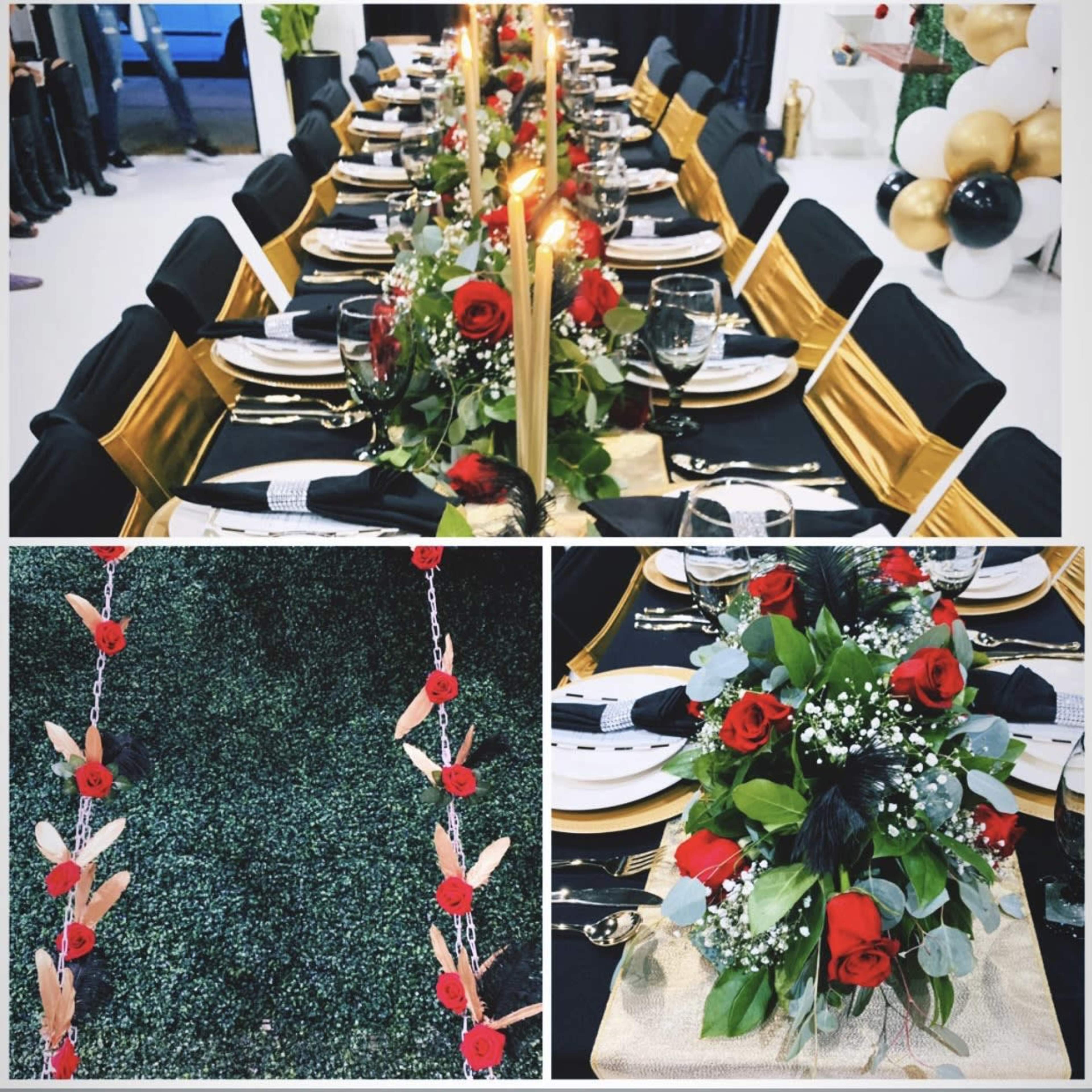 A decorated dining setup with a long table set with black and gold accents, red roses, candles, and elegant tableware.