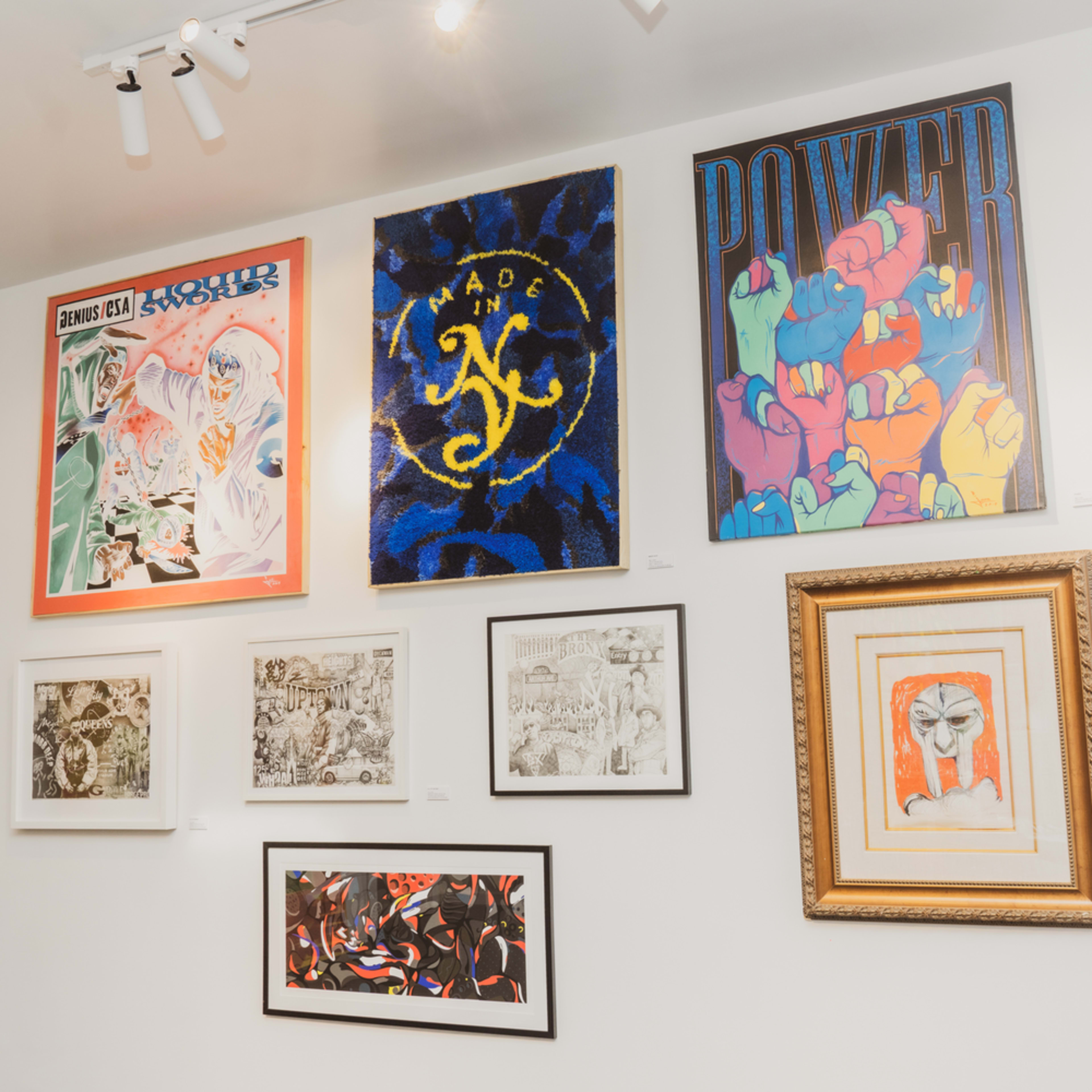 A gallery wall displaying a collection of various framed artworks, including colorful posters and illustrations.
