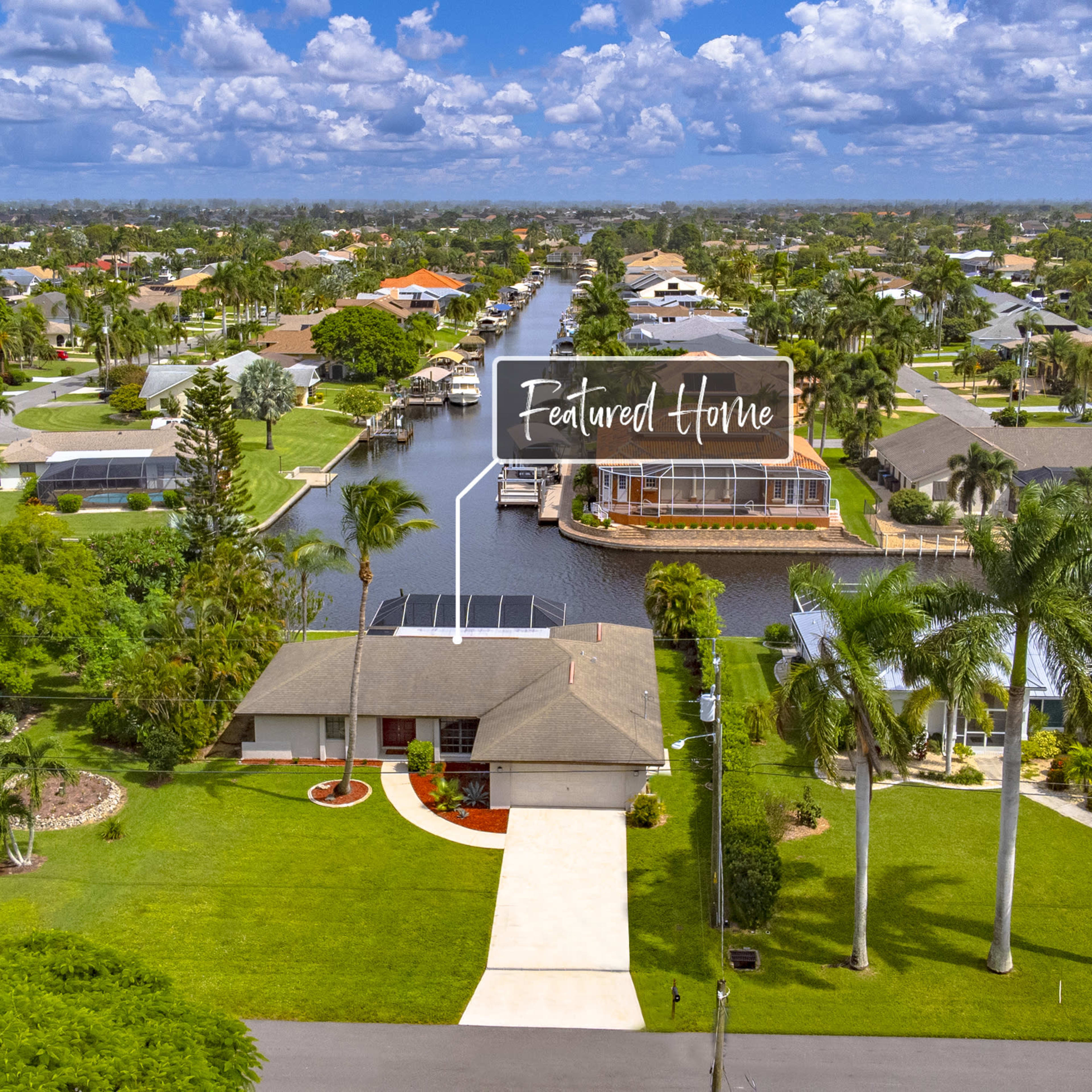 A suburban neighborhood with a waterfront property prominently labeled as "Featured Home" and surrounded by greenery and other houses.