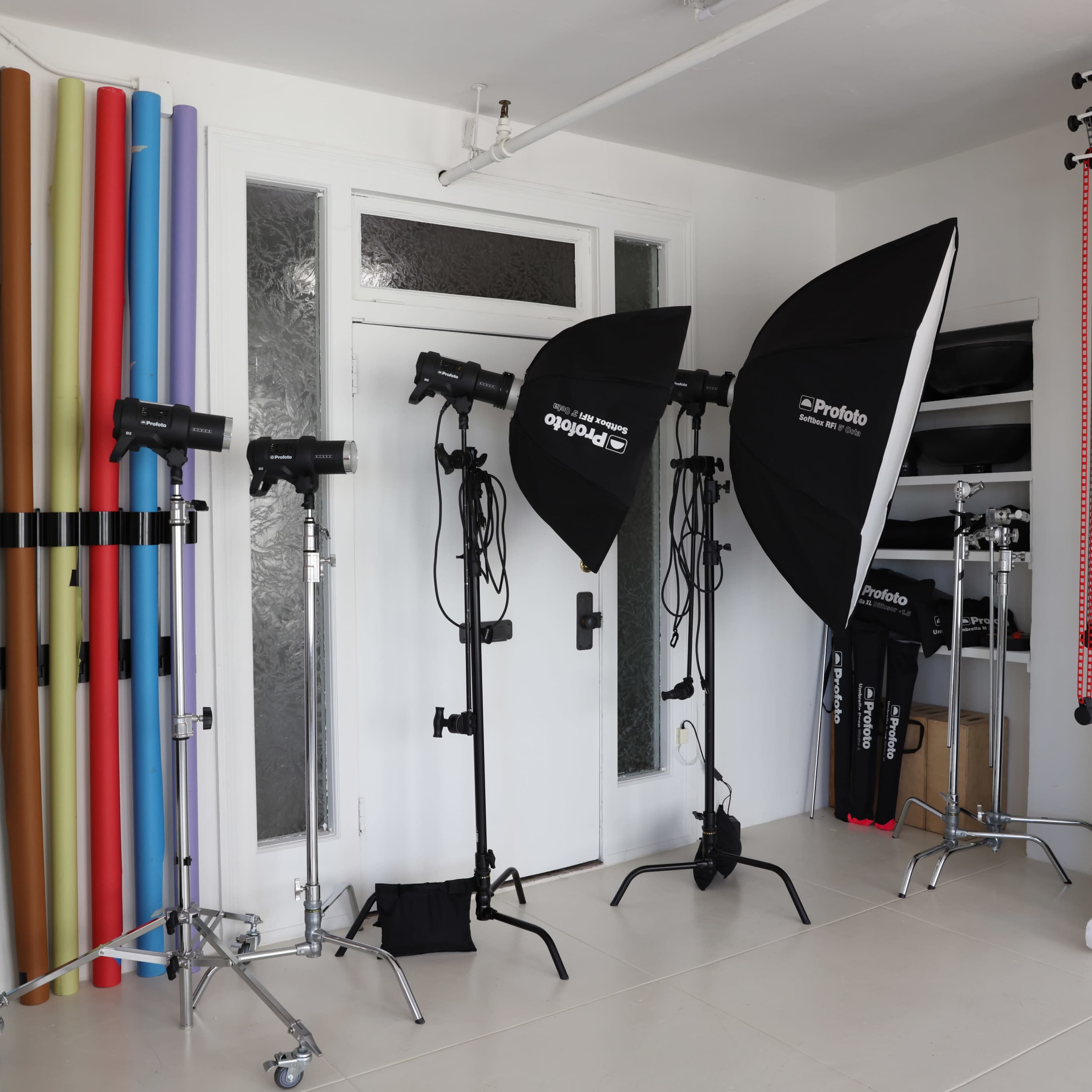 A photography studio with various lighting equipment, backdrops in different colors, and a clean, organized workspace.