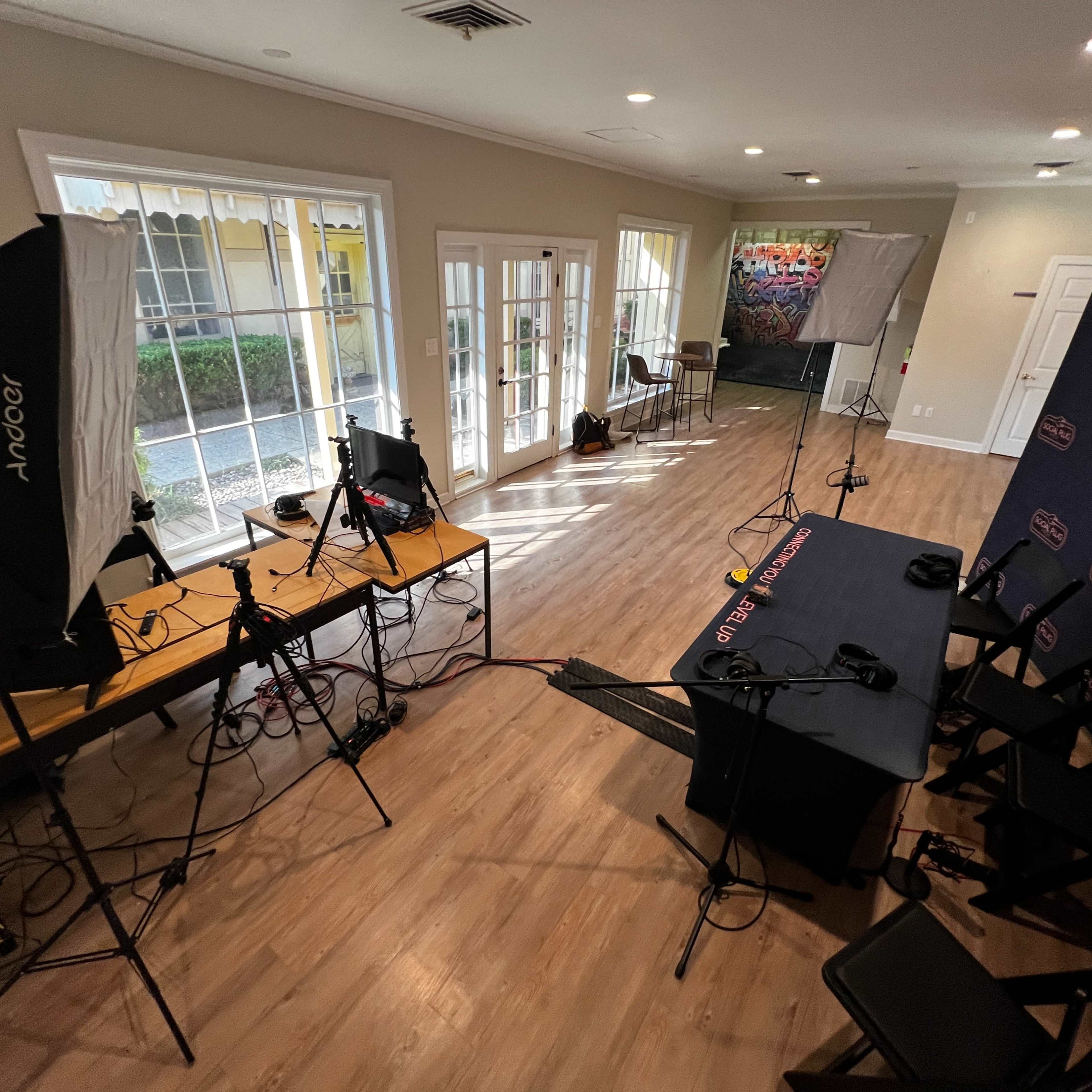 A well-equipped interview setup in a room with a table, chairs, and lighting equipment.