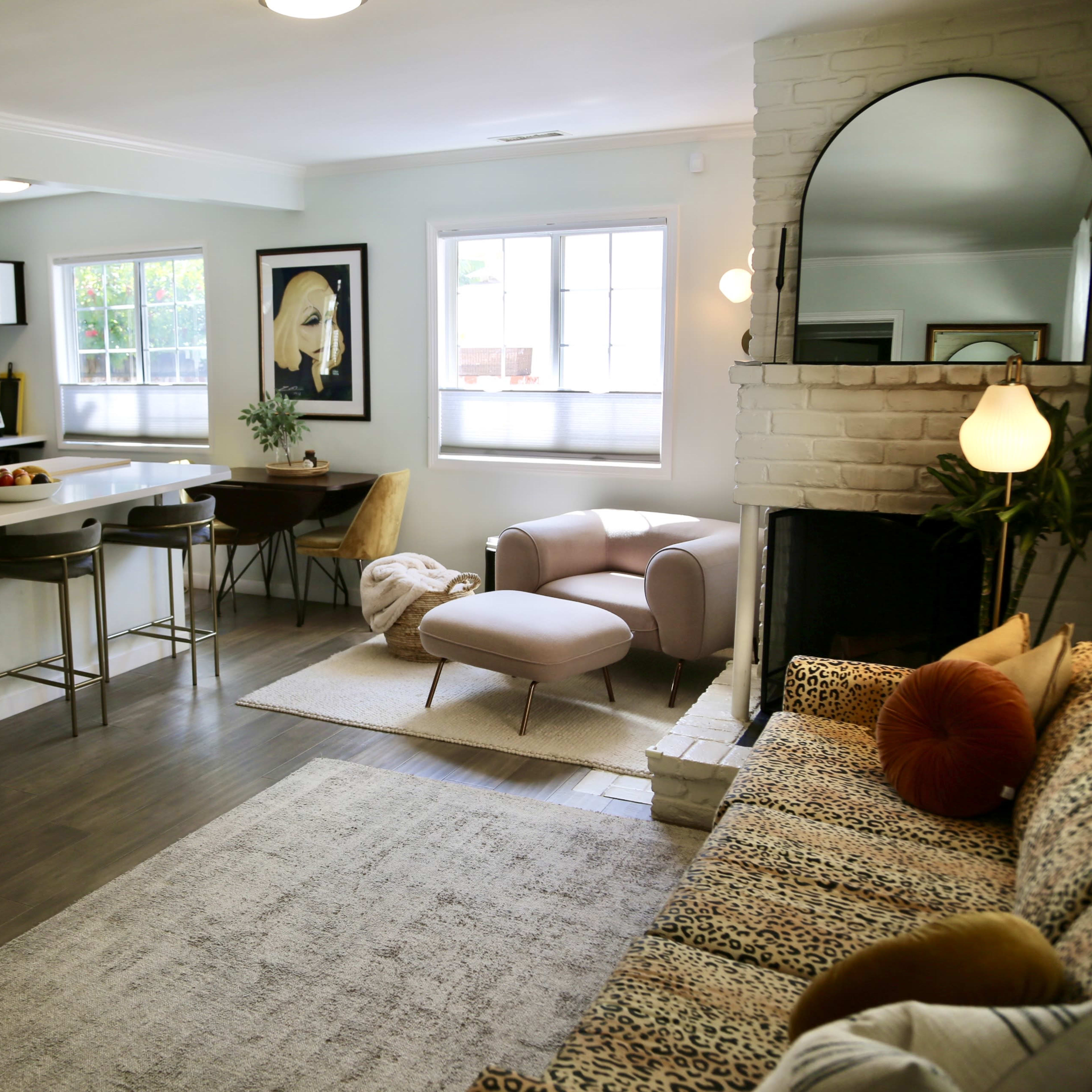 A modern living room and kitchen area with a plush sofa, dining table, and a sleek kitchen island.