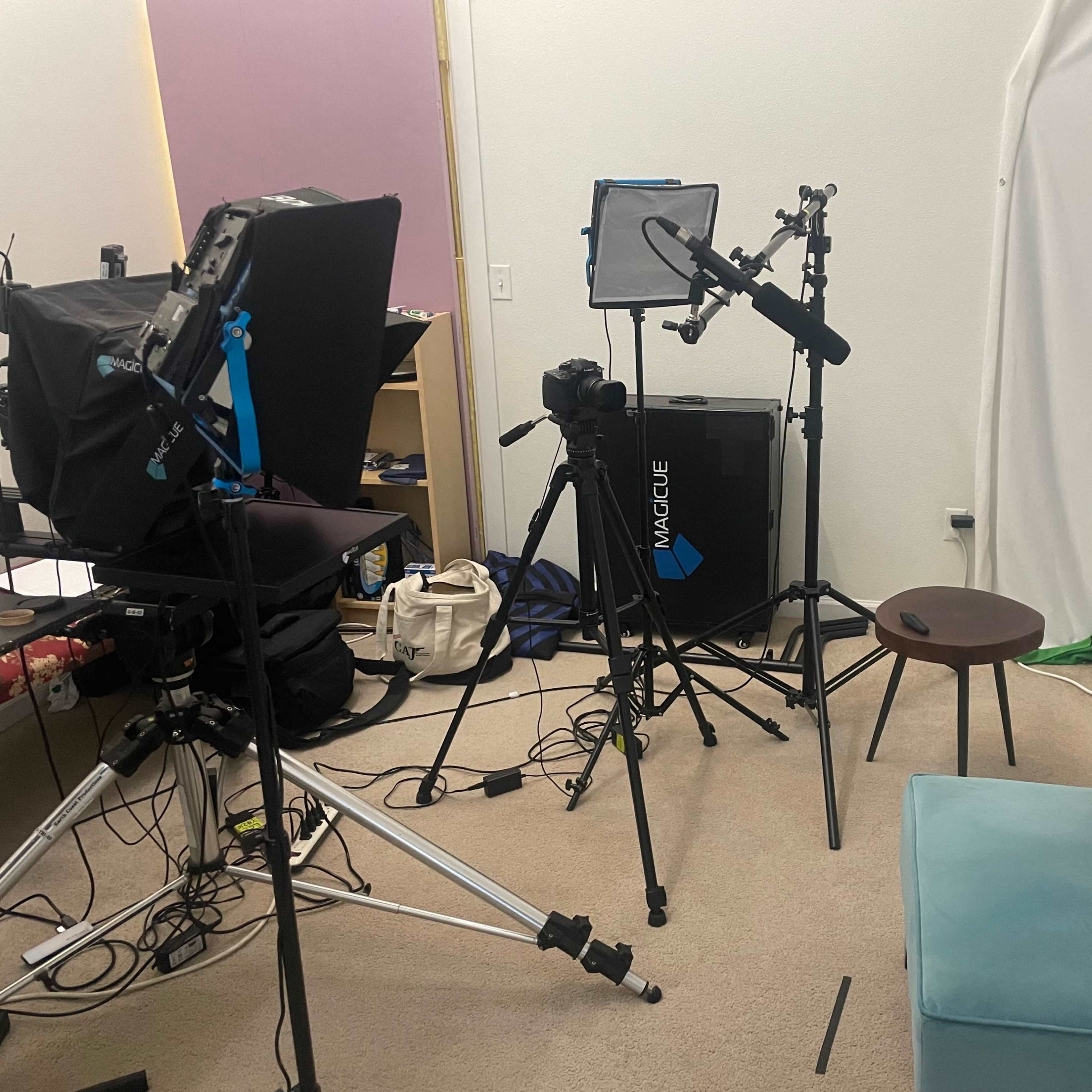 A video recording setup with a chair, camera equipment, and lighting in a studio environment.