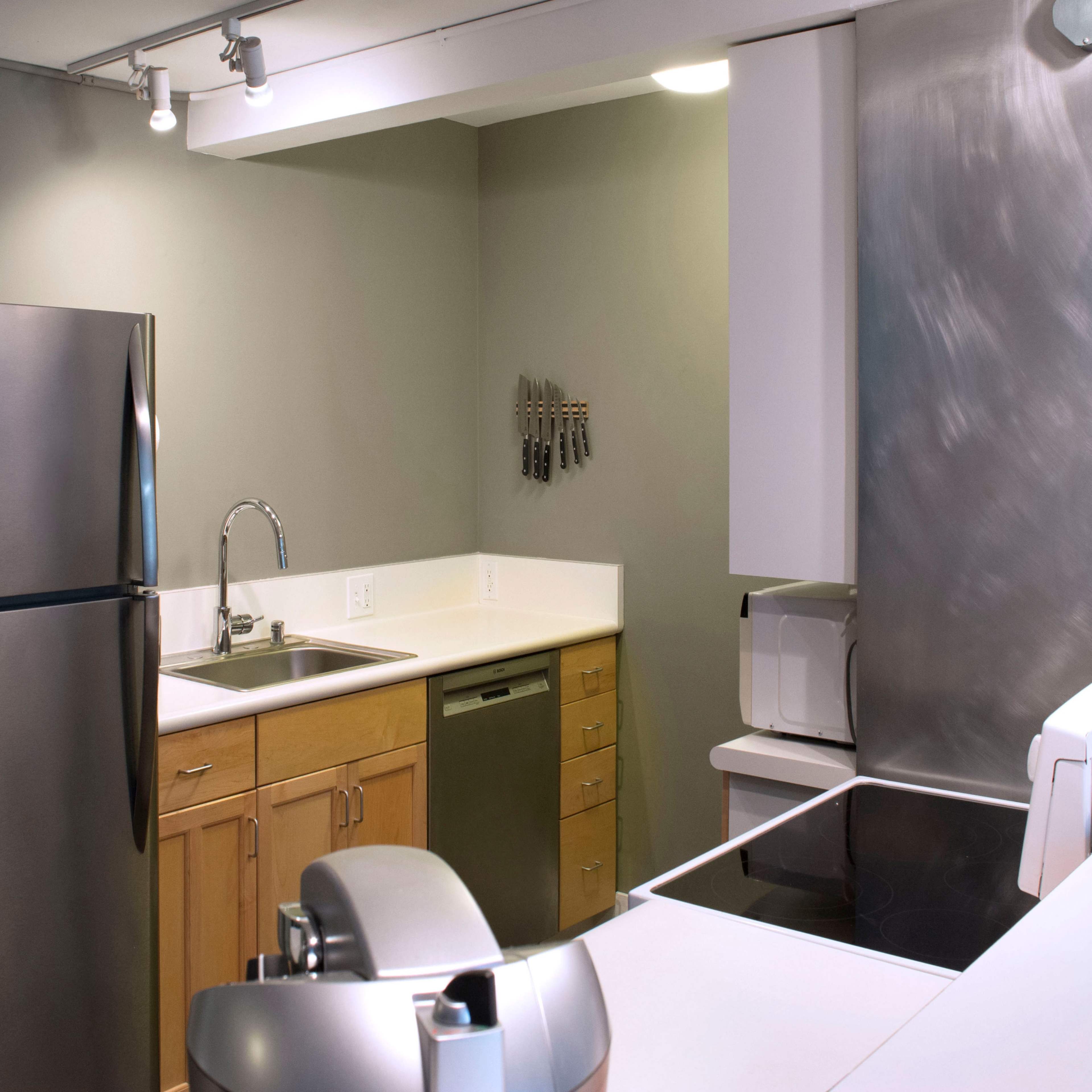 A modern kitchen features stainless steel appliances, wooden cabinets, and a spacious countertop.