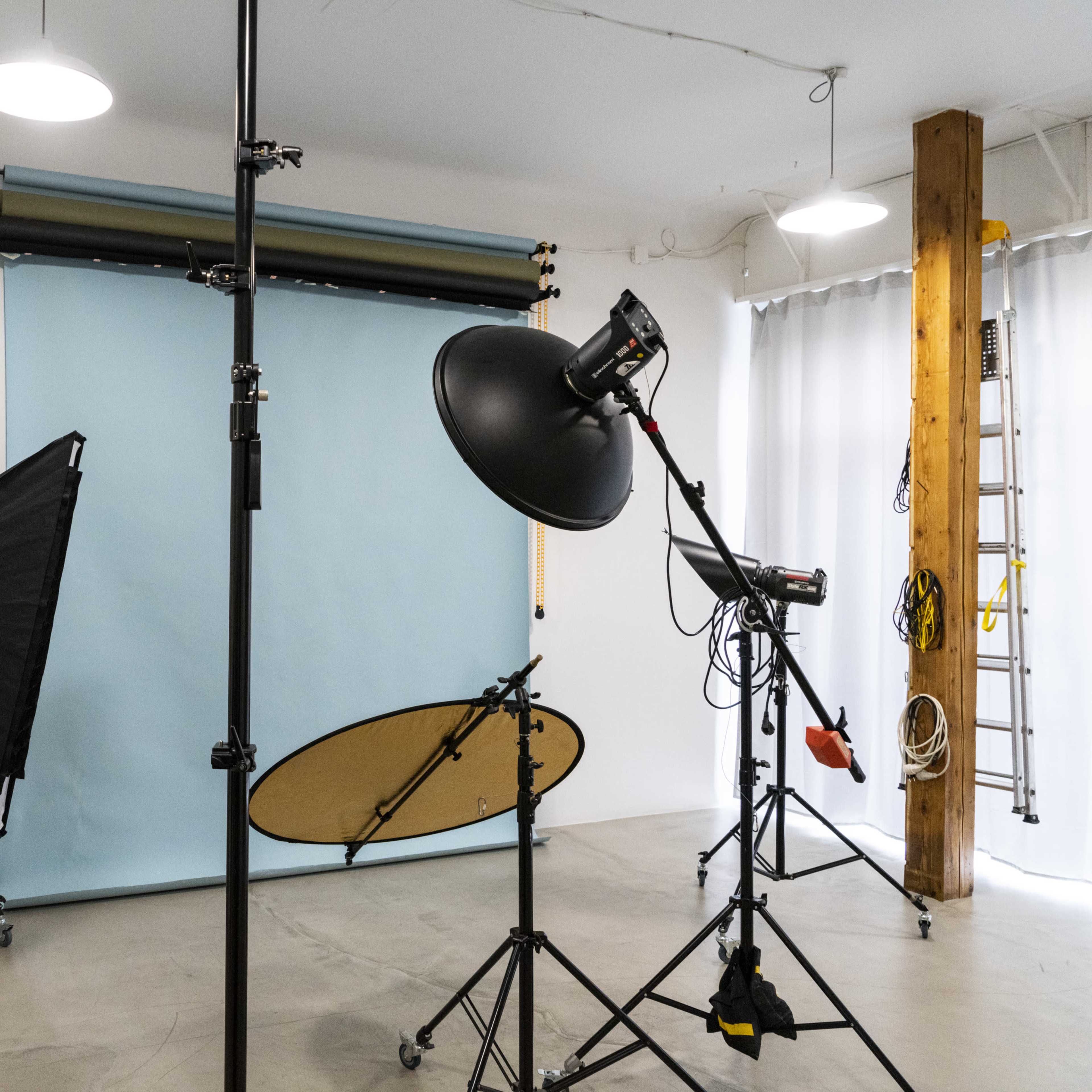 A photography studio equipped with lighting equipment, a backdrop, and various tools for taking pictures.
