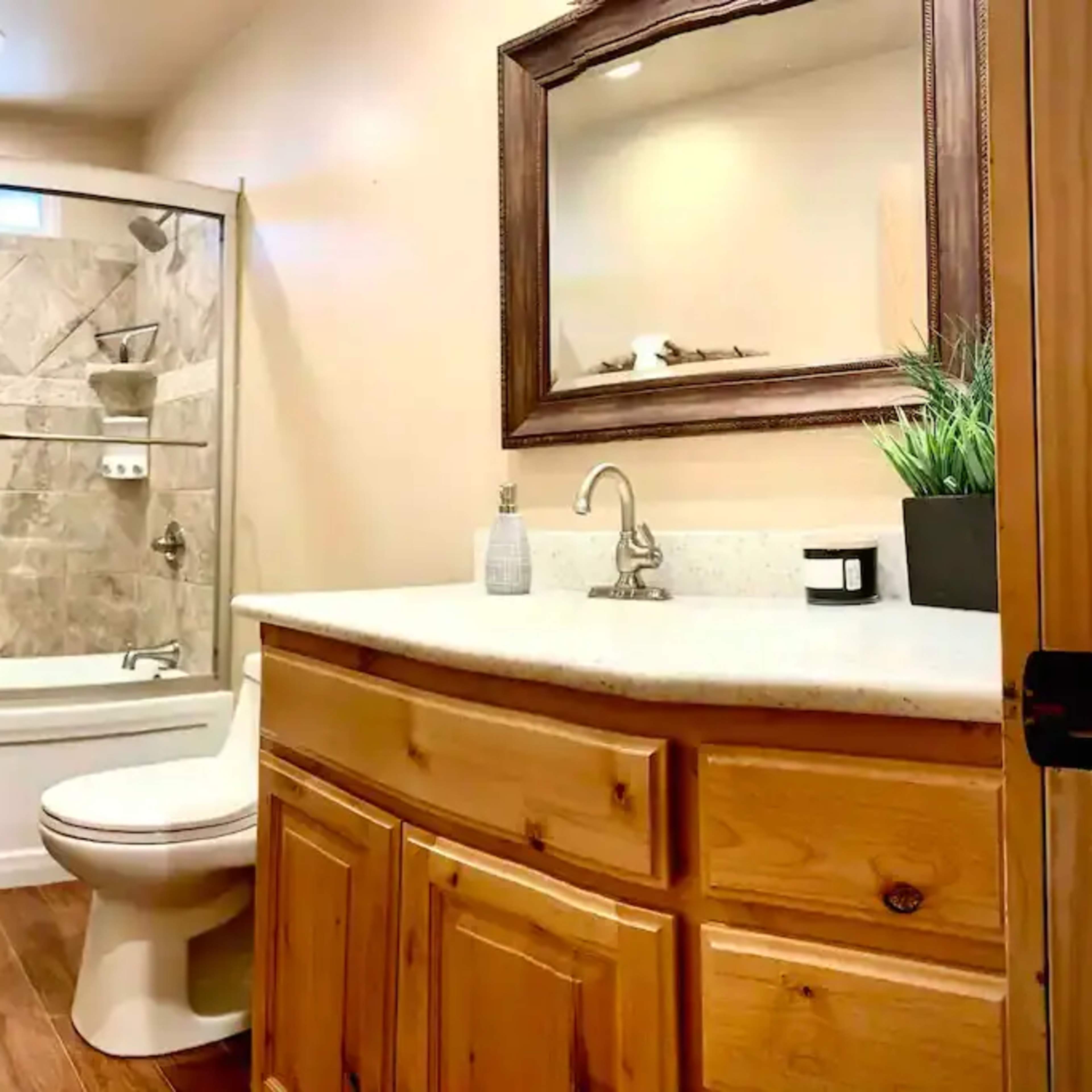 A bathroom featuring a tub shower combination, wooden cabinetry, a sink, and a mirror.