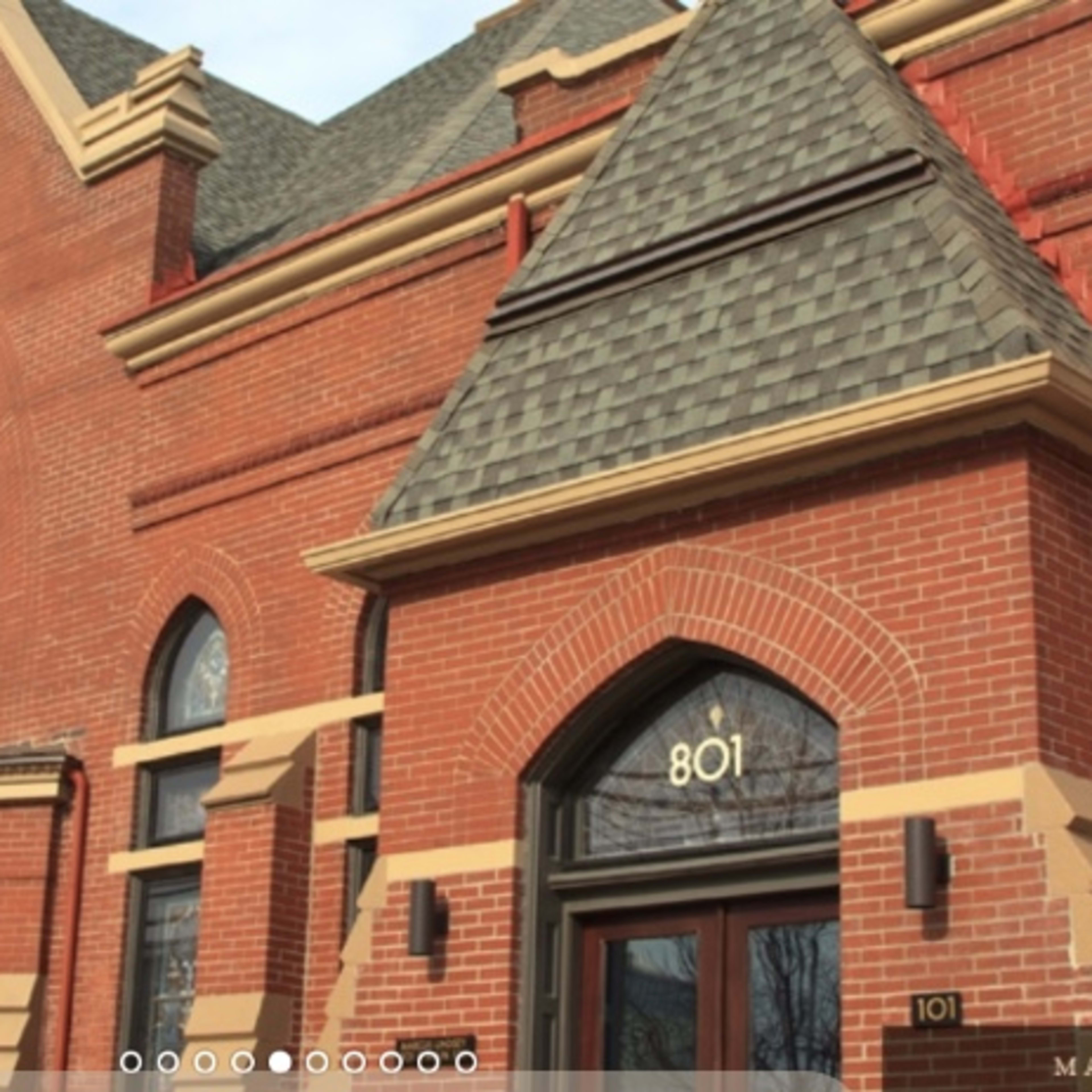 The exterior of a large brick building featuring arched windows and a prominent entrance.