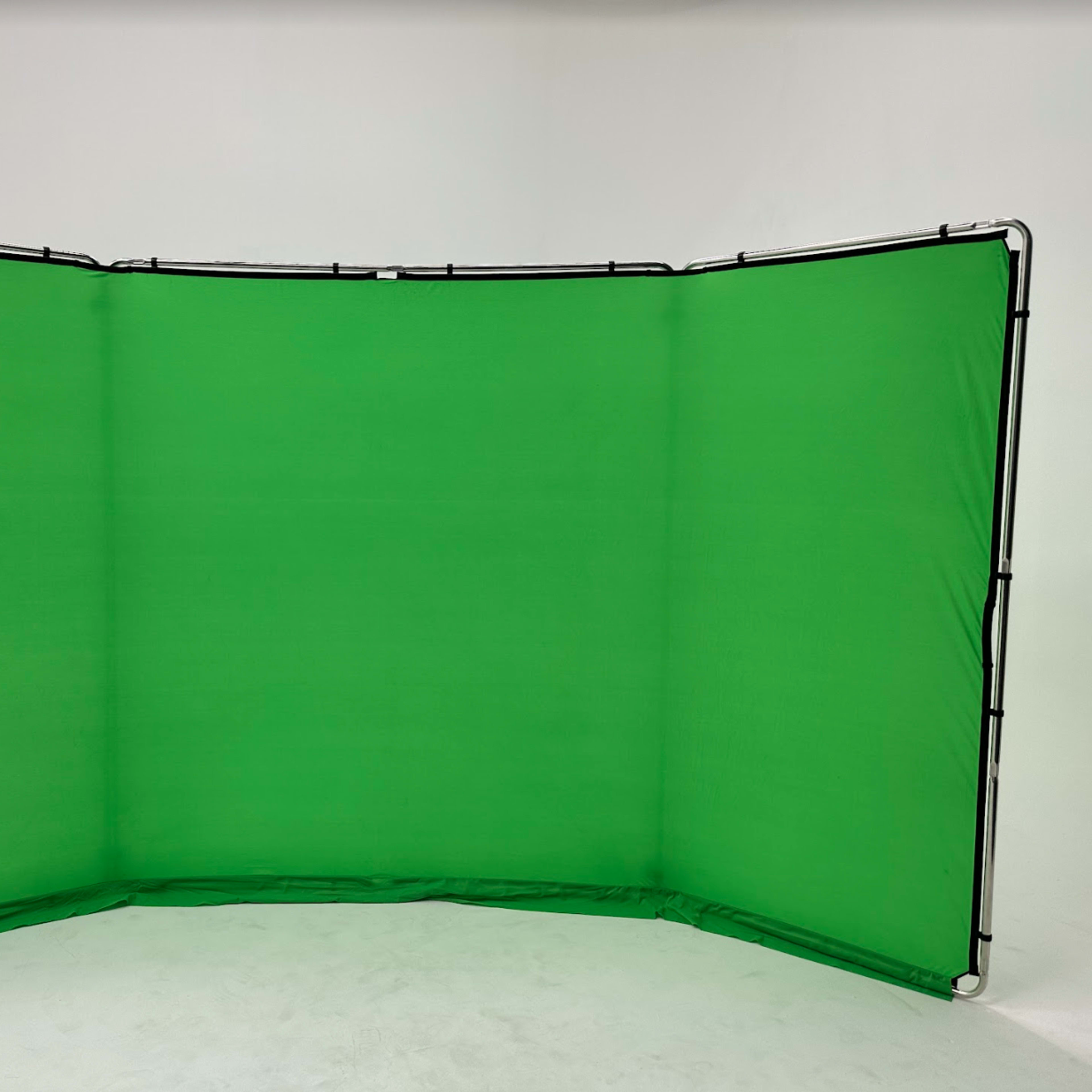 A large green backdrop set up on a white surface, likely for photography or video production.
