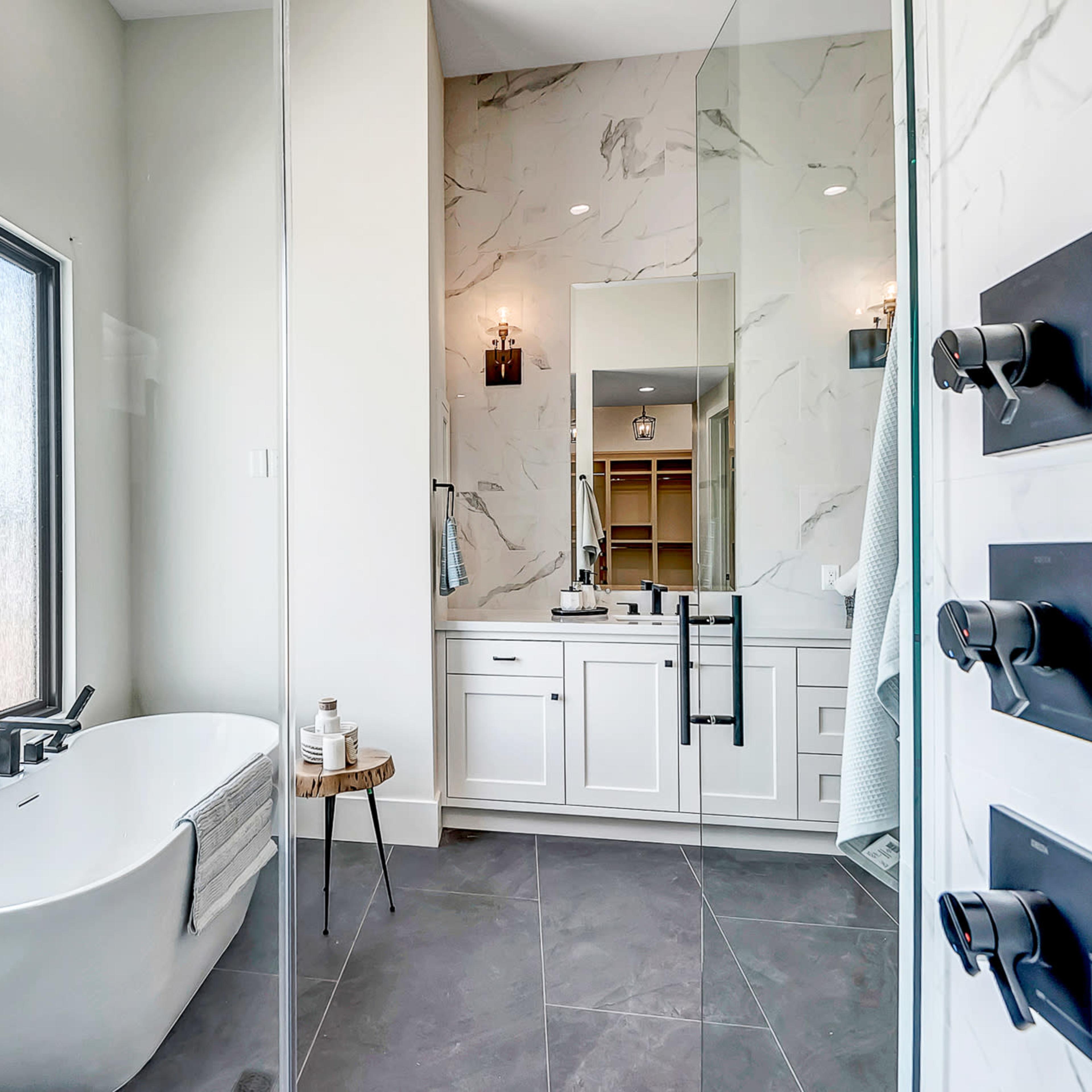 A modern bathroom featuring a freestanding bathtub, a walk-in shower with glass panels, and a double vanity with sinks.