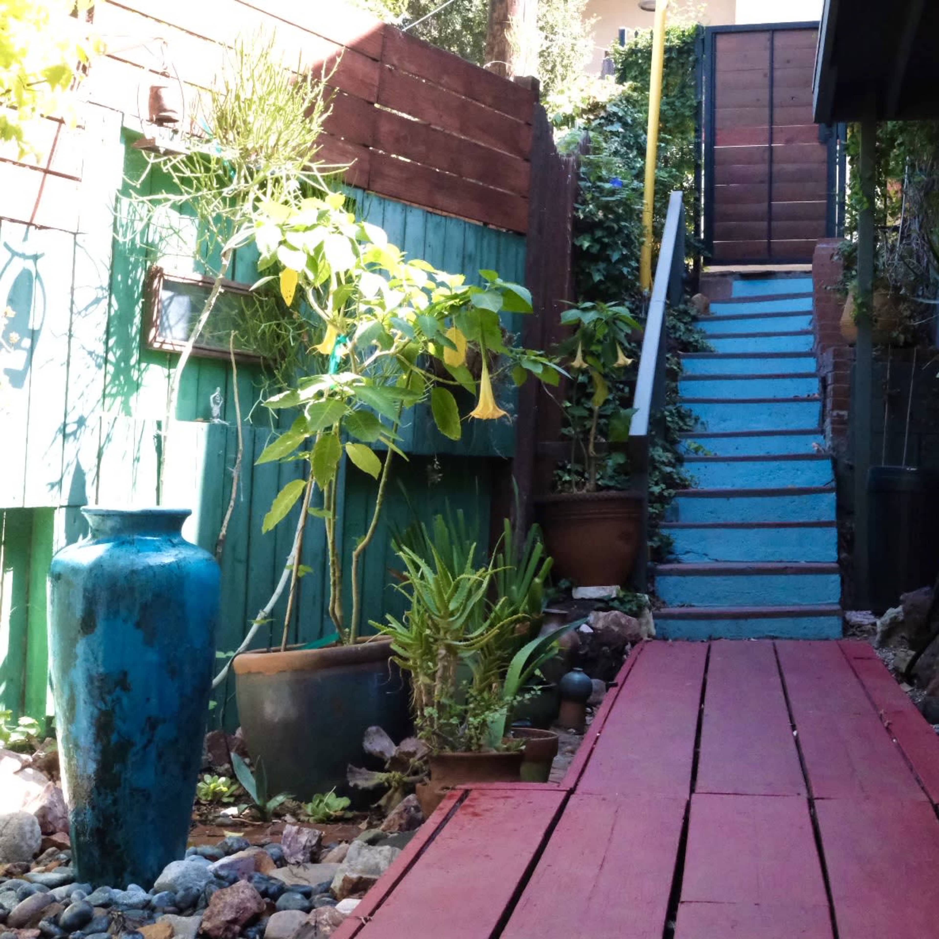 Green outdoor parklike hillside deck available for gatherings, dinners, parties, events, babyshowers, photoshoots. Large yard awash in trees and plants tucked into the hills with fully stocked chef's kitchen, living room, beautiful unique spaces Image in Woodland Hills, Los Angeles, CA