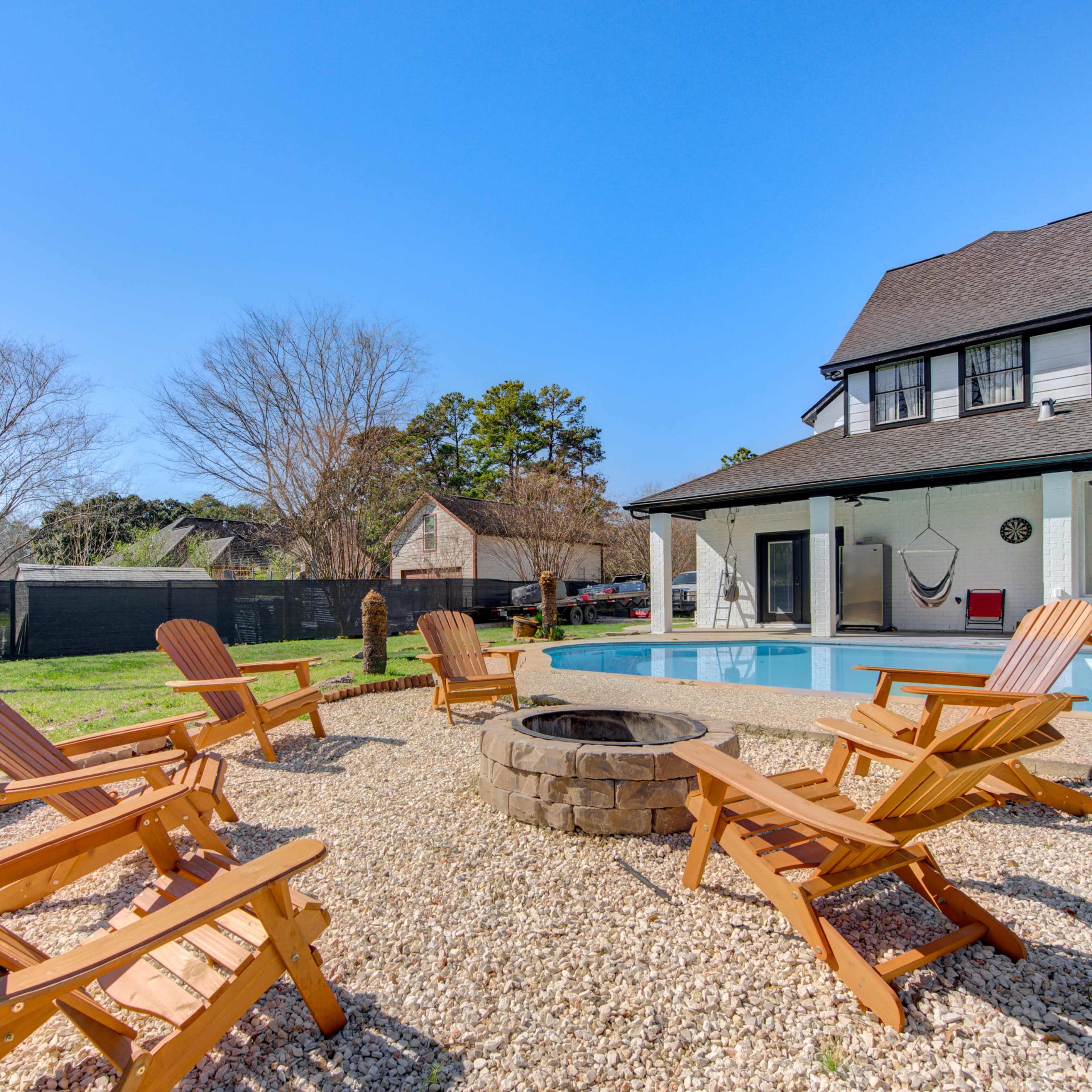 The scene shows a backyard with a swimming pool, surrounded by wooden lounge chairs and a fire pit, with a house and trees in the background.