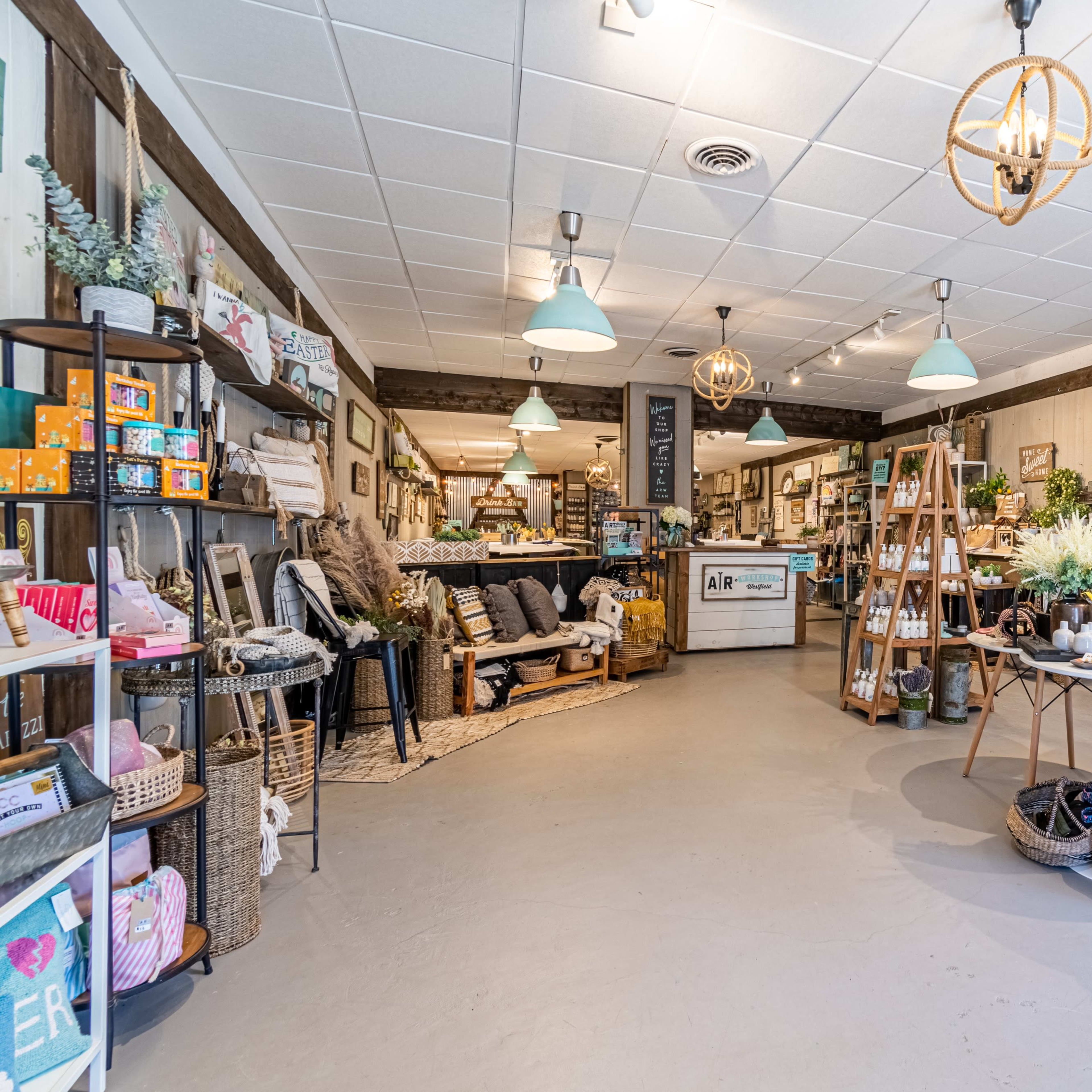 A brightly lit boutique with various home decor items and furniture arranged throughout the space.