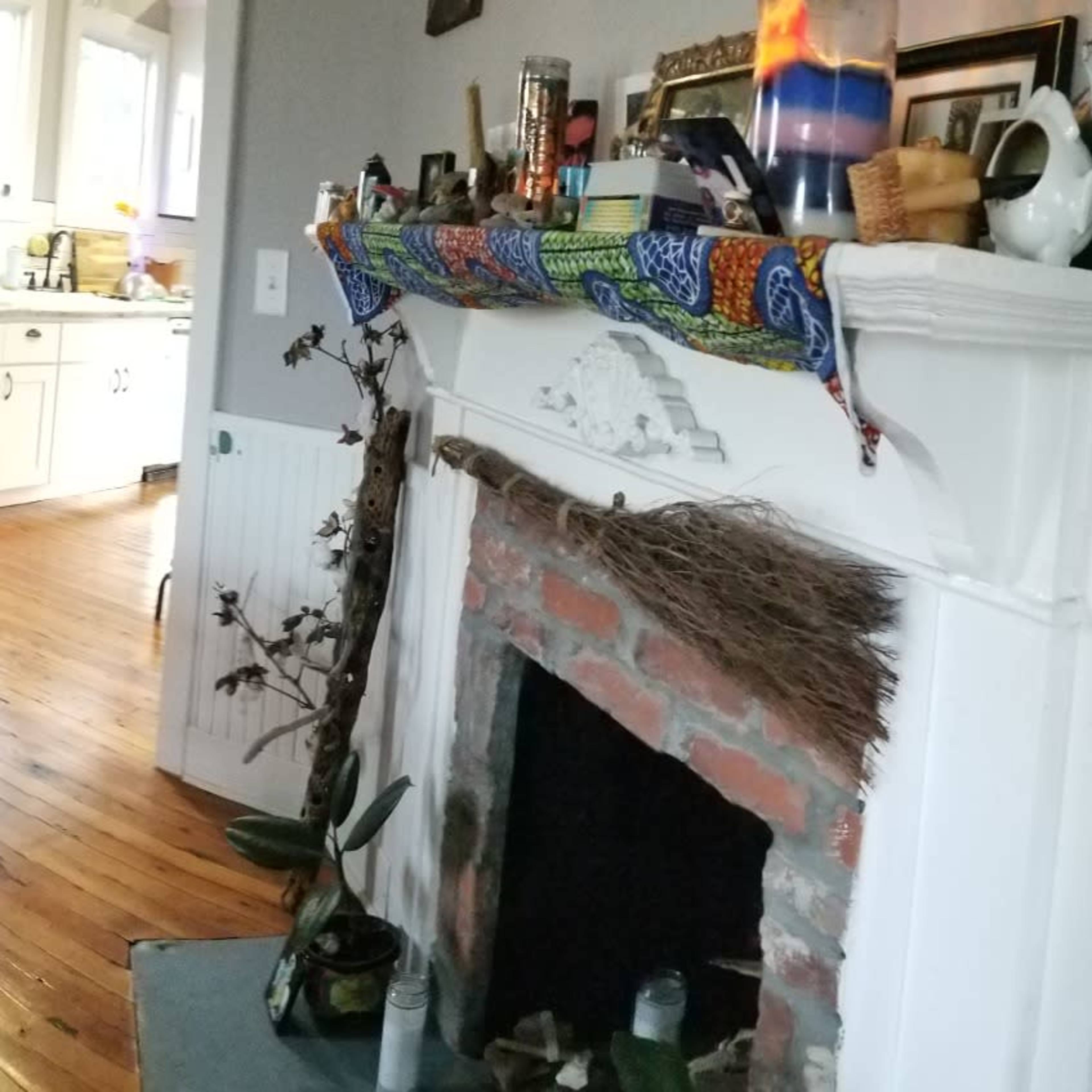 A cozy living and dining area with a large table set for a meal, a gray sofa, and a decorated fireplace.