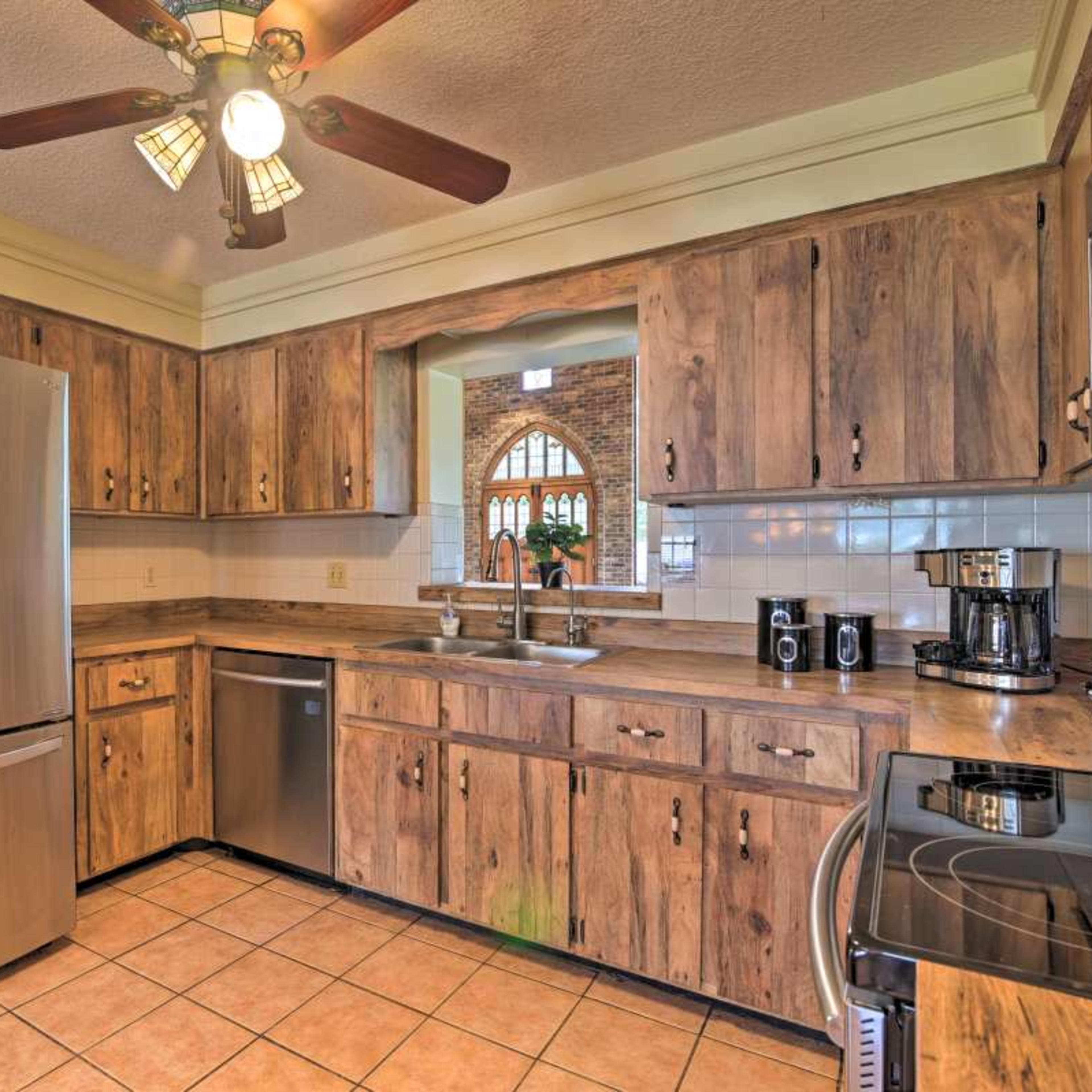 A kitchen with wooden cabinets, stainless steel appliances, and tiled flooring.