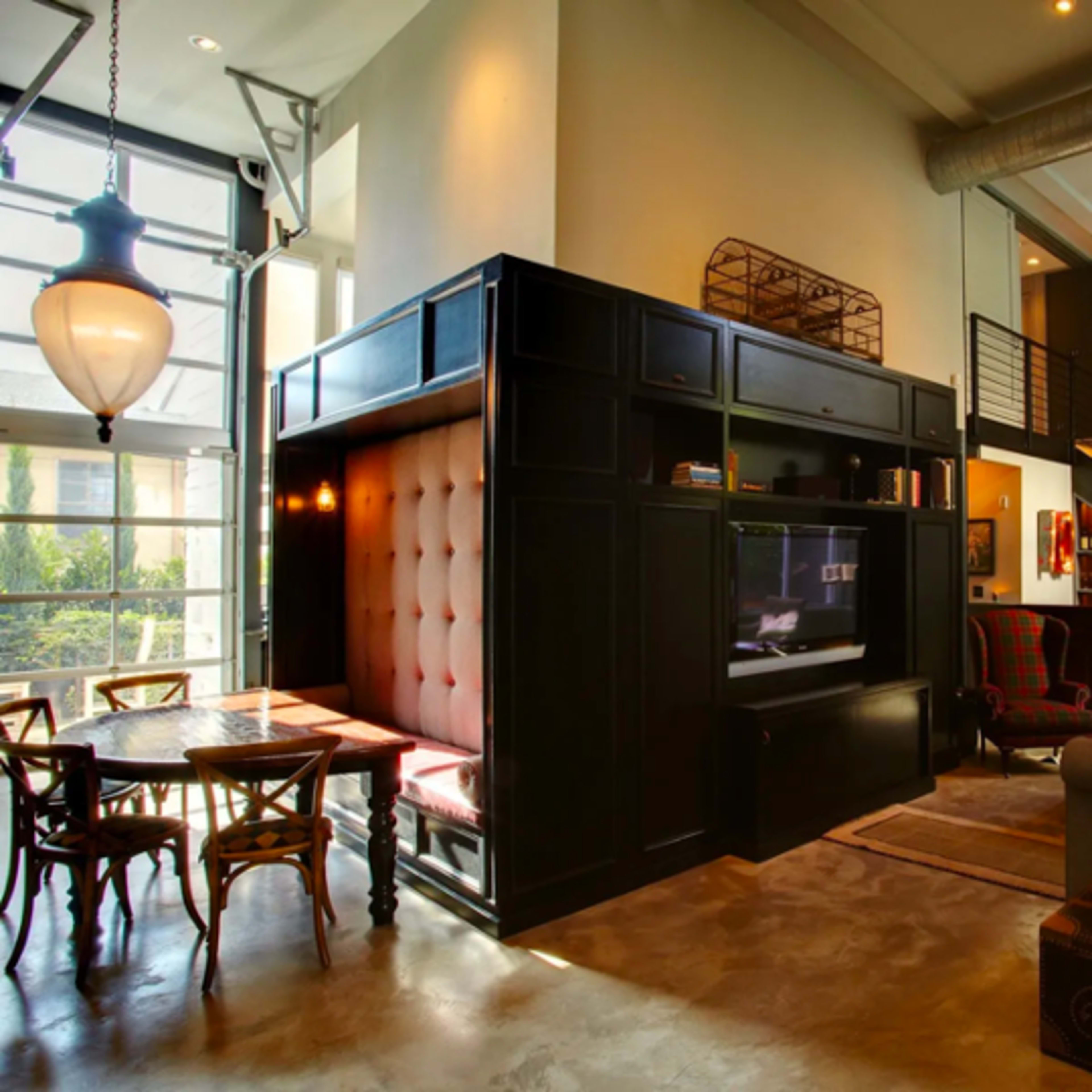 A modern living space with a mix of seating areas, a staircase, and a decorative wall mounted with a deer head.