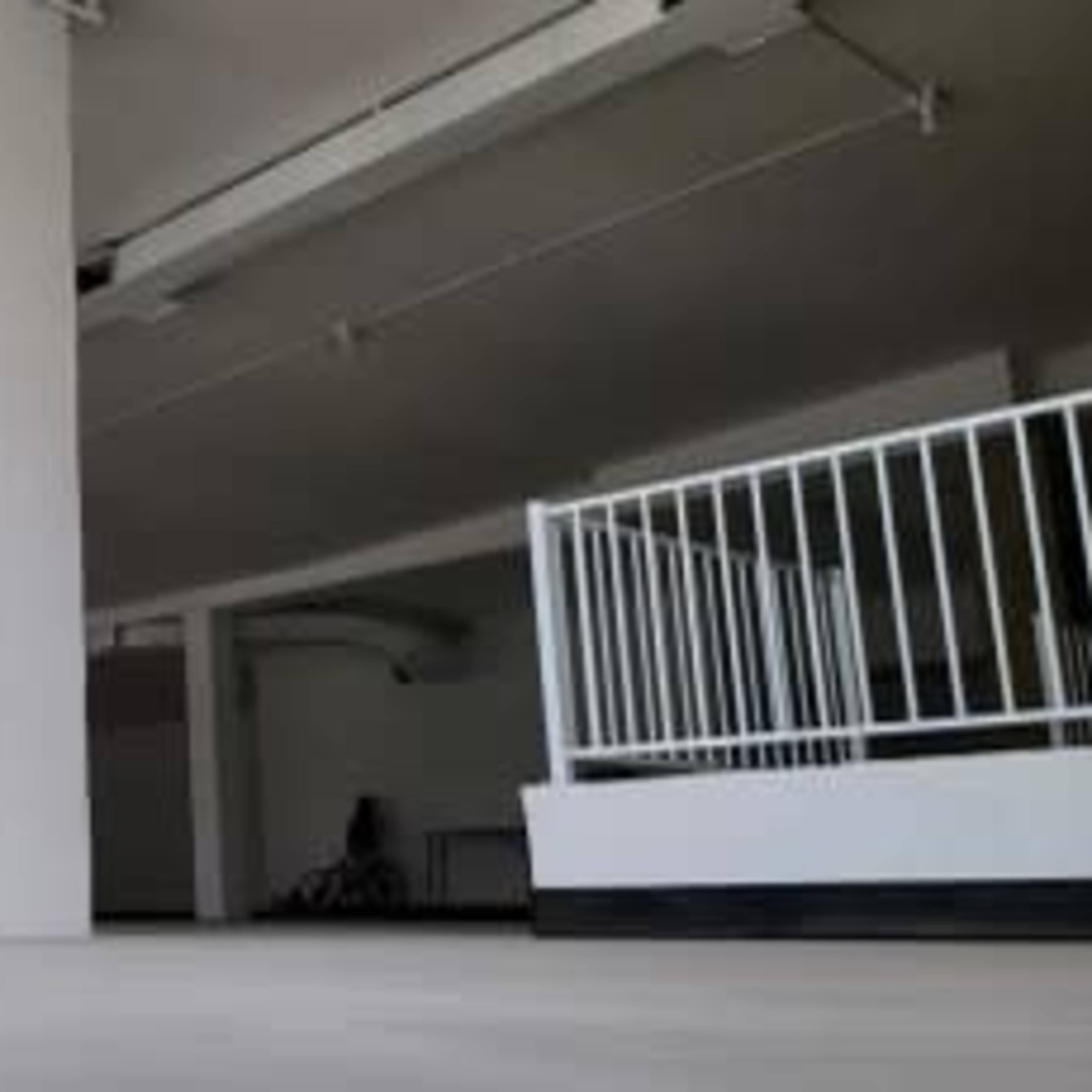 An empty, well-lit interior space with white walls and a smooth floor.