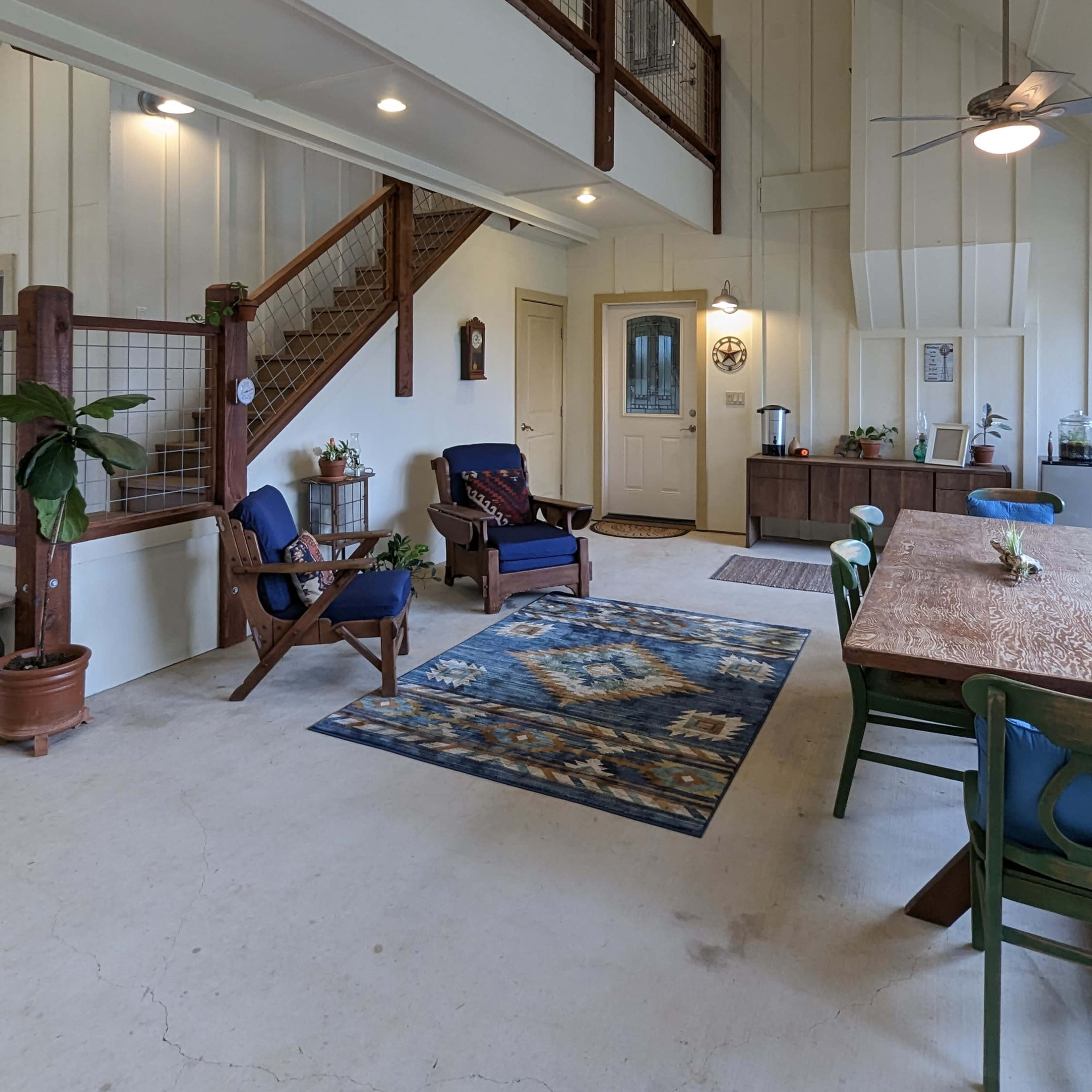 The interior features a spacious, open layout with a dining area, living space, and a staircase leading to a loft.