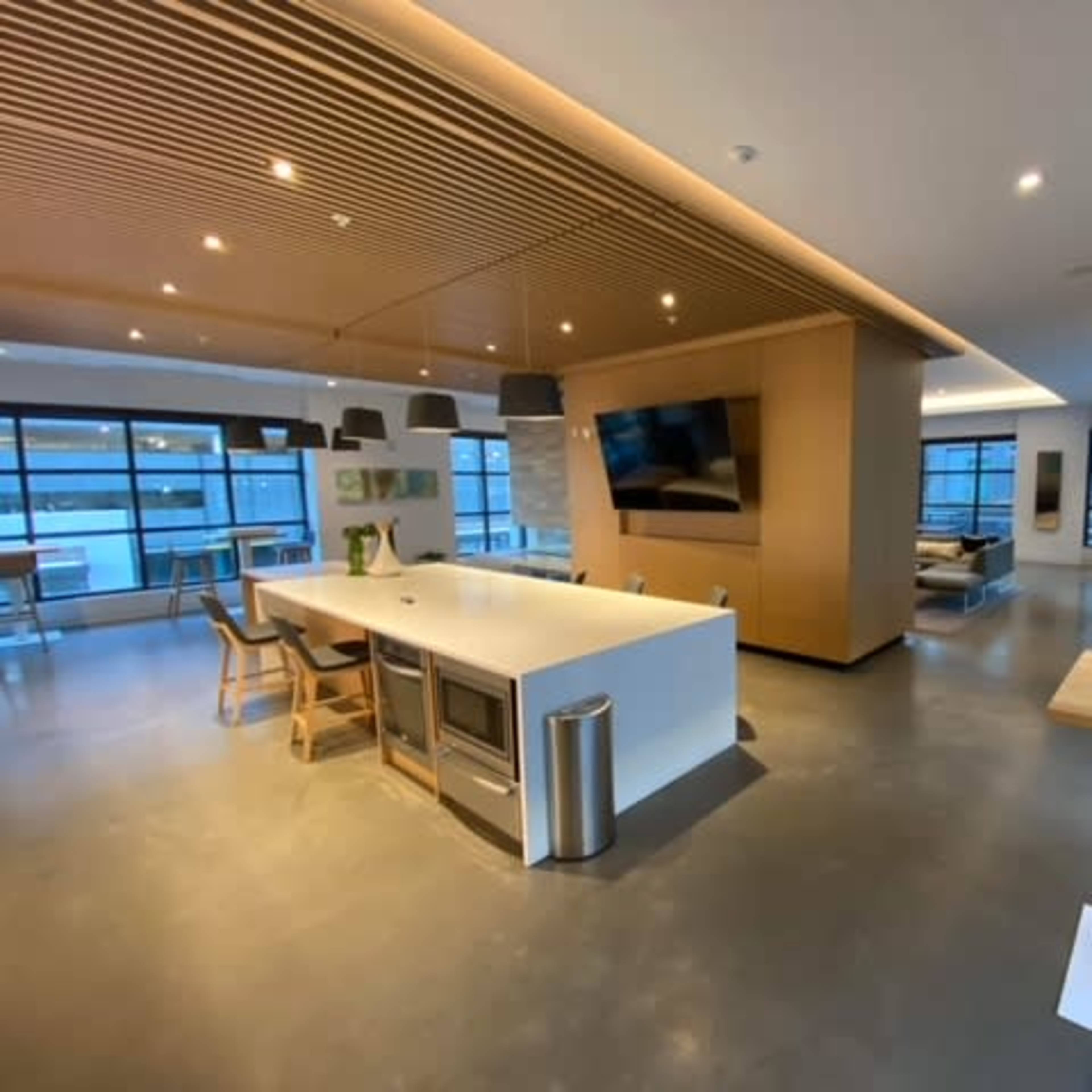 A modern open-plan kitchen and lounge area with sleek furniture and large windows.