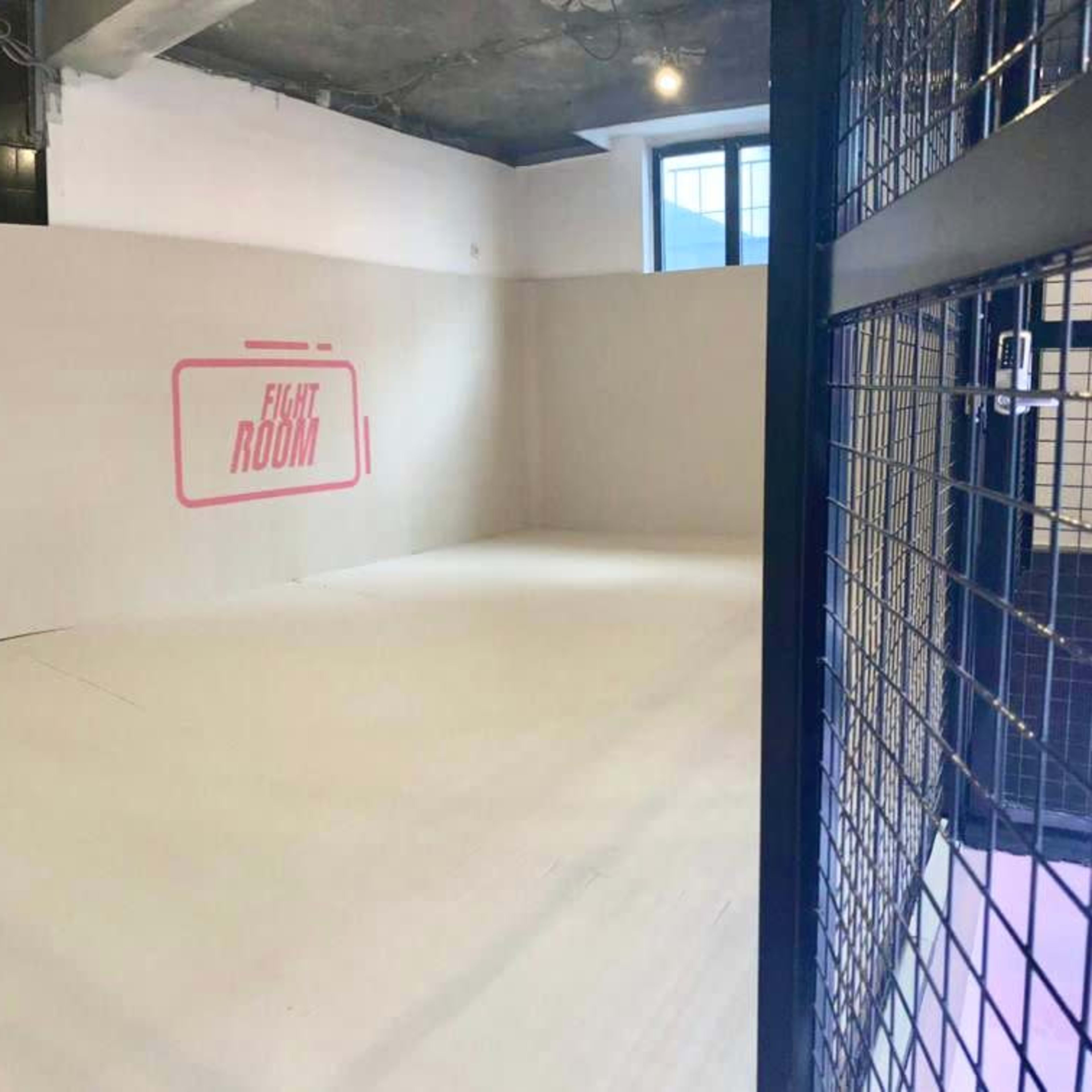 A sparsely decorated room with white walls and a large sign that reads "FIGHT ROOM."