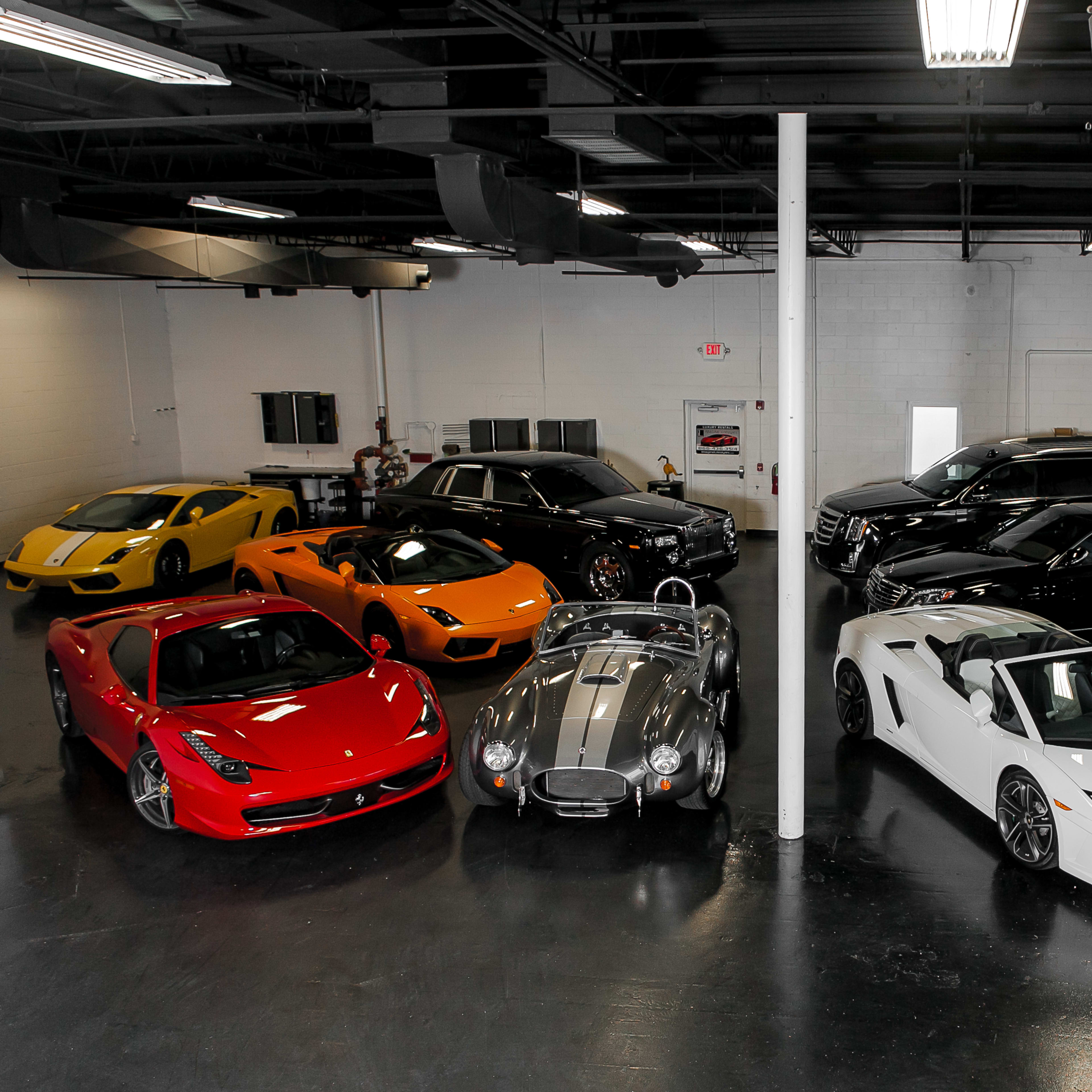 A collection of luxury and sports cars parked in a spacious garage.