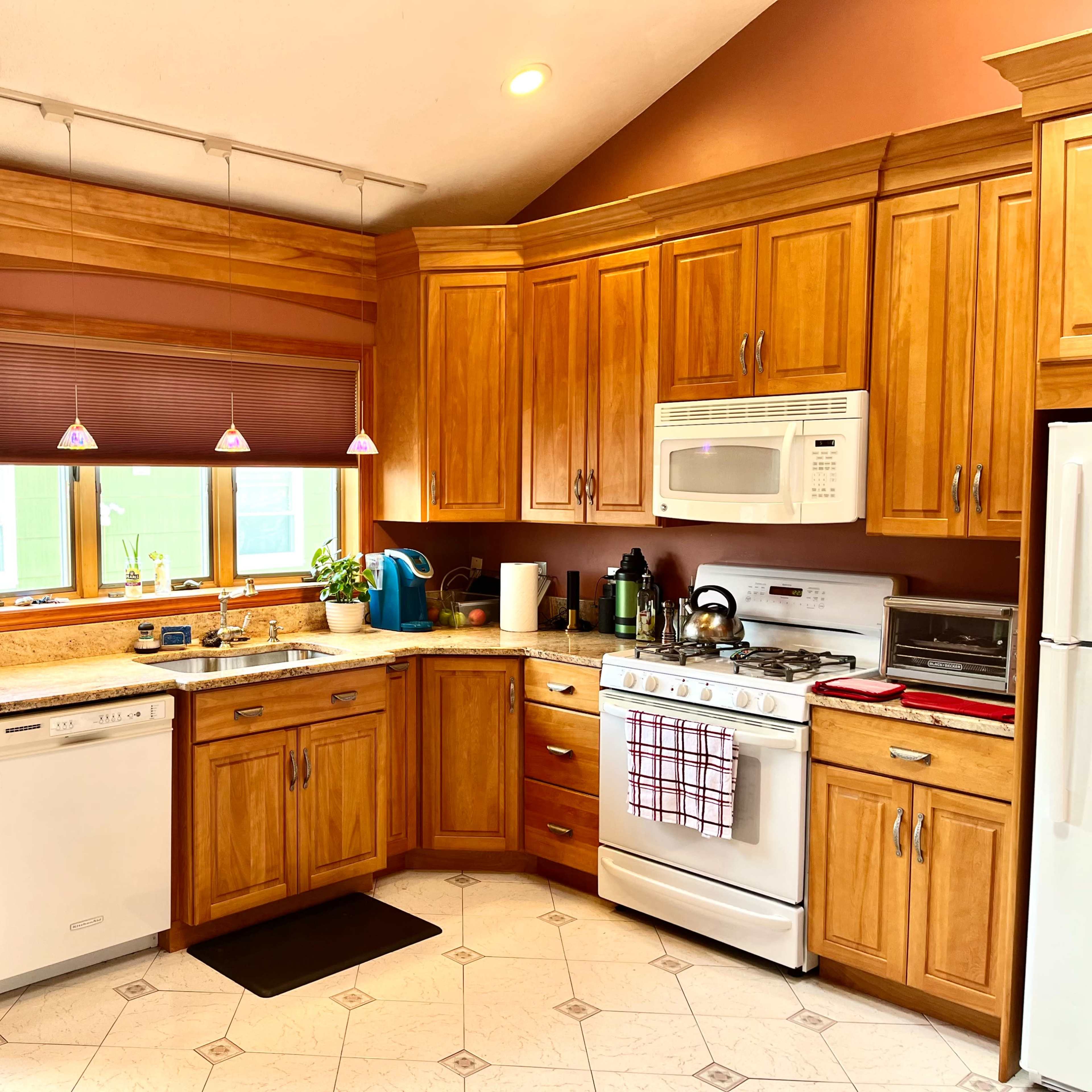 A well-organized kitchen with wooden cabinets, a white stove, and a countertop featuring a small plant and kitchen appliances.