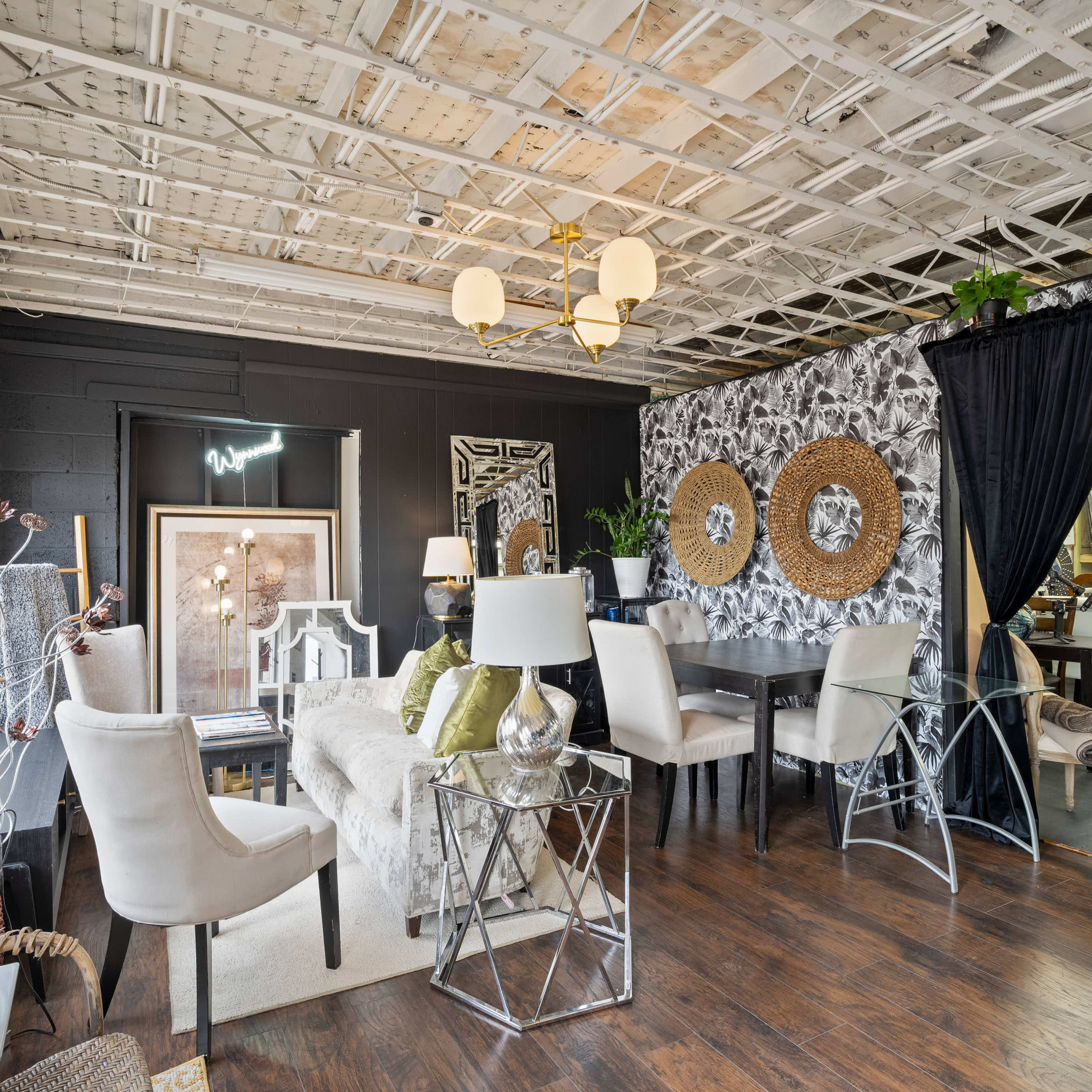 A modern interior of a home furnishings showroom featuring seating areas, decorative wall art, and various light fixtures.