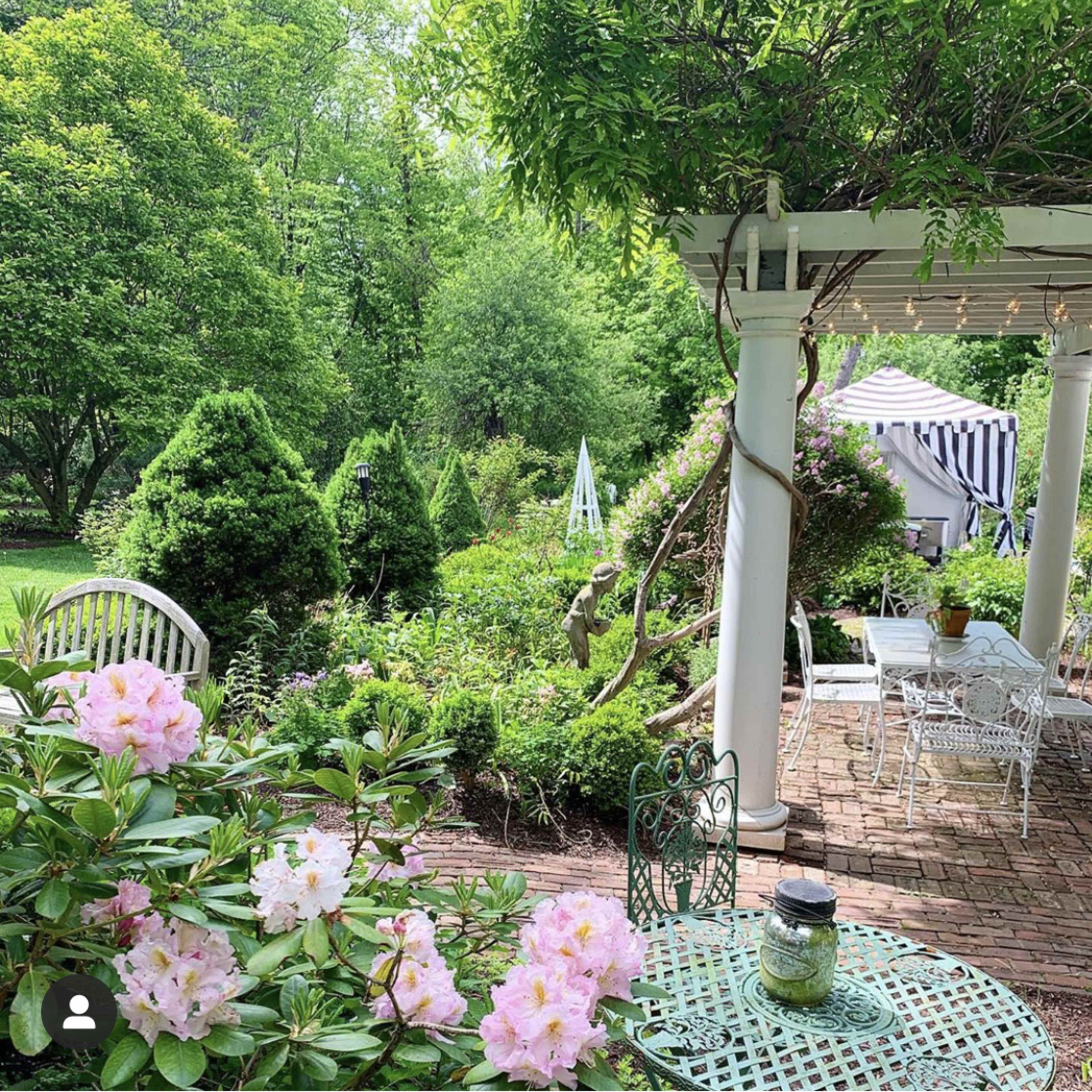 A garden scene features blooming pink flowers in the foreground, a white gazebo, and lush greenery in the background.
