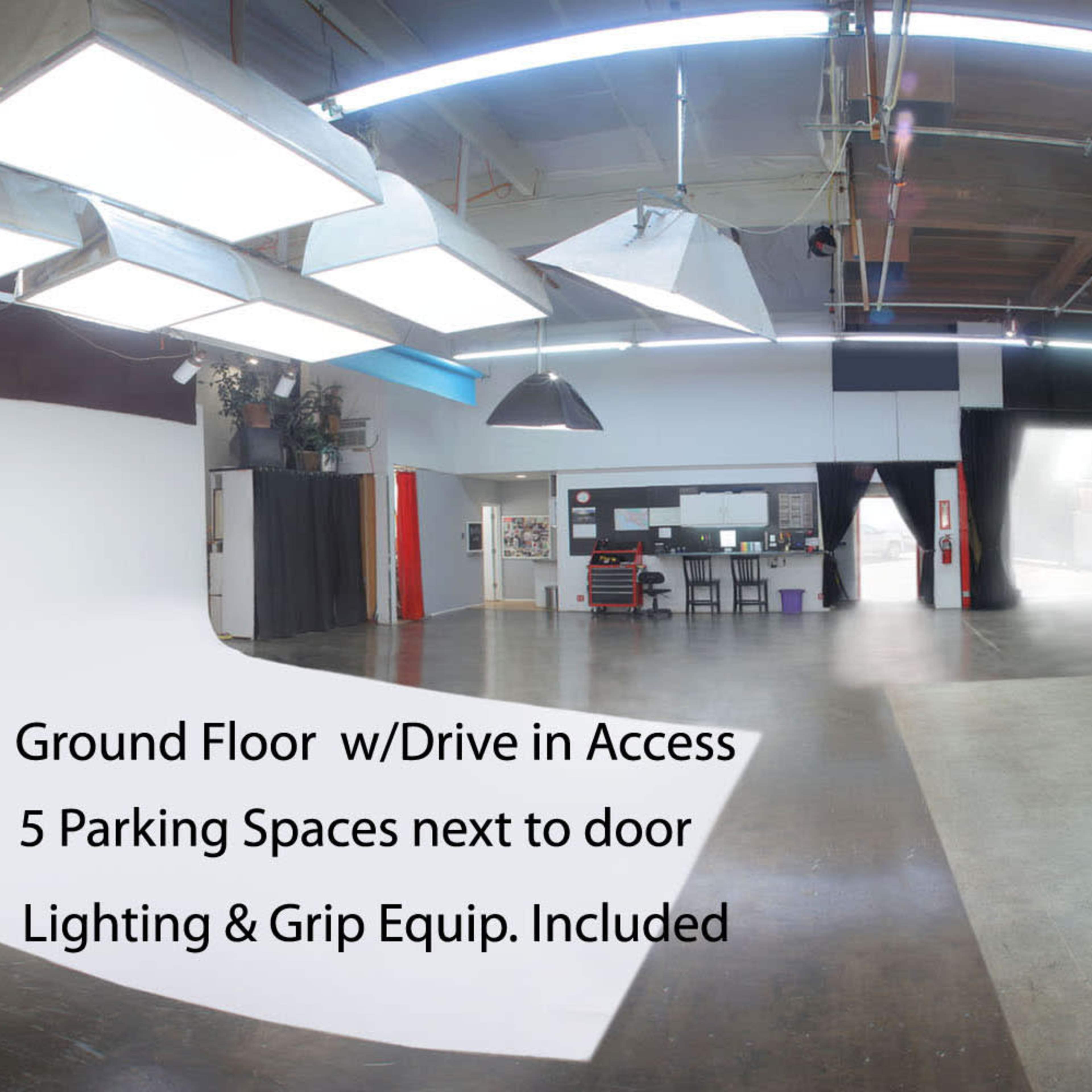 A spacious photography studio with a white backdrop, hardwood floor, and various lighting equipment, along with a description of its features.