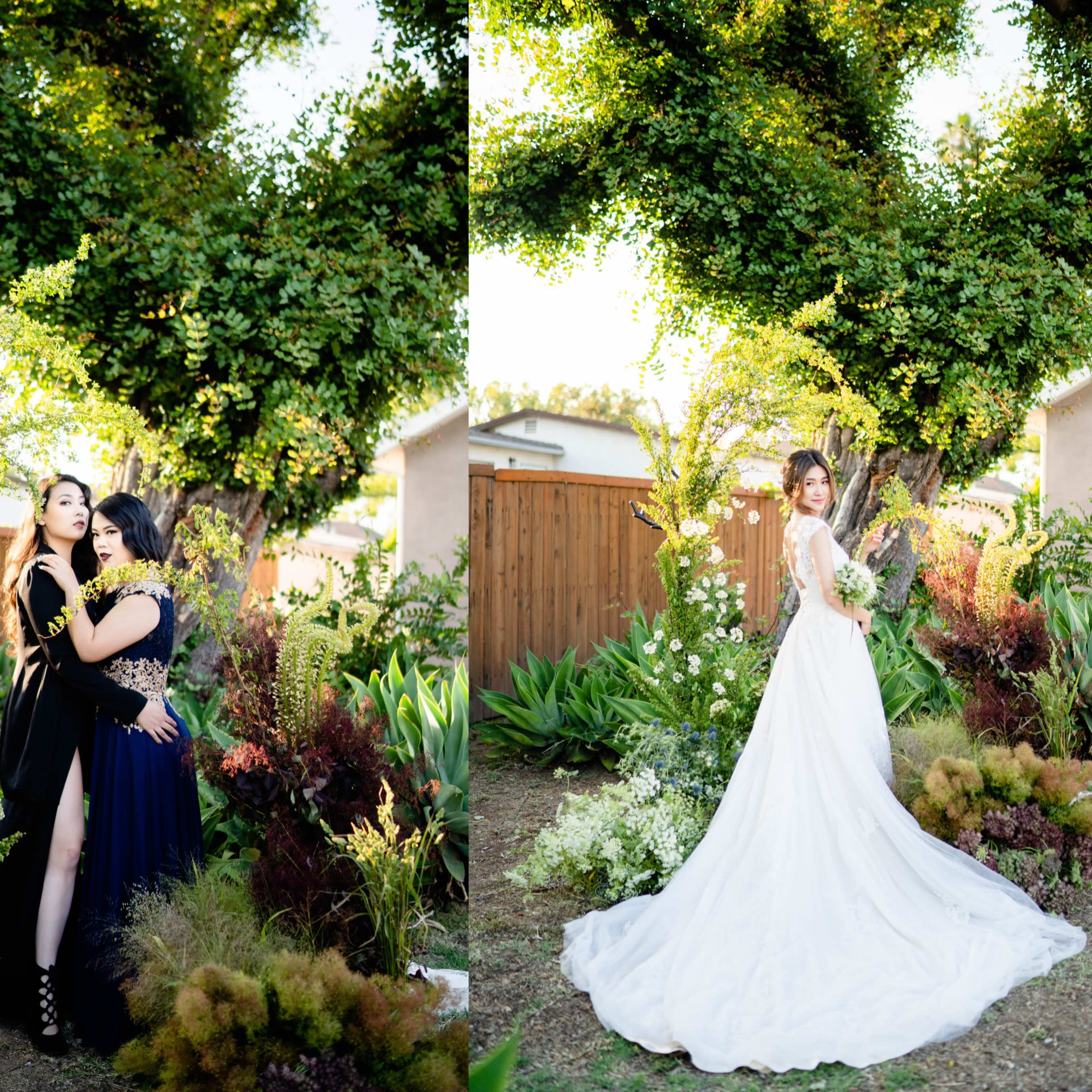 Three women posing in a garden setting, surrounded by lush greenery and flowering plants.