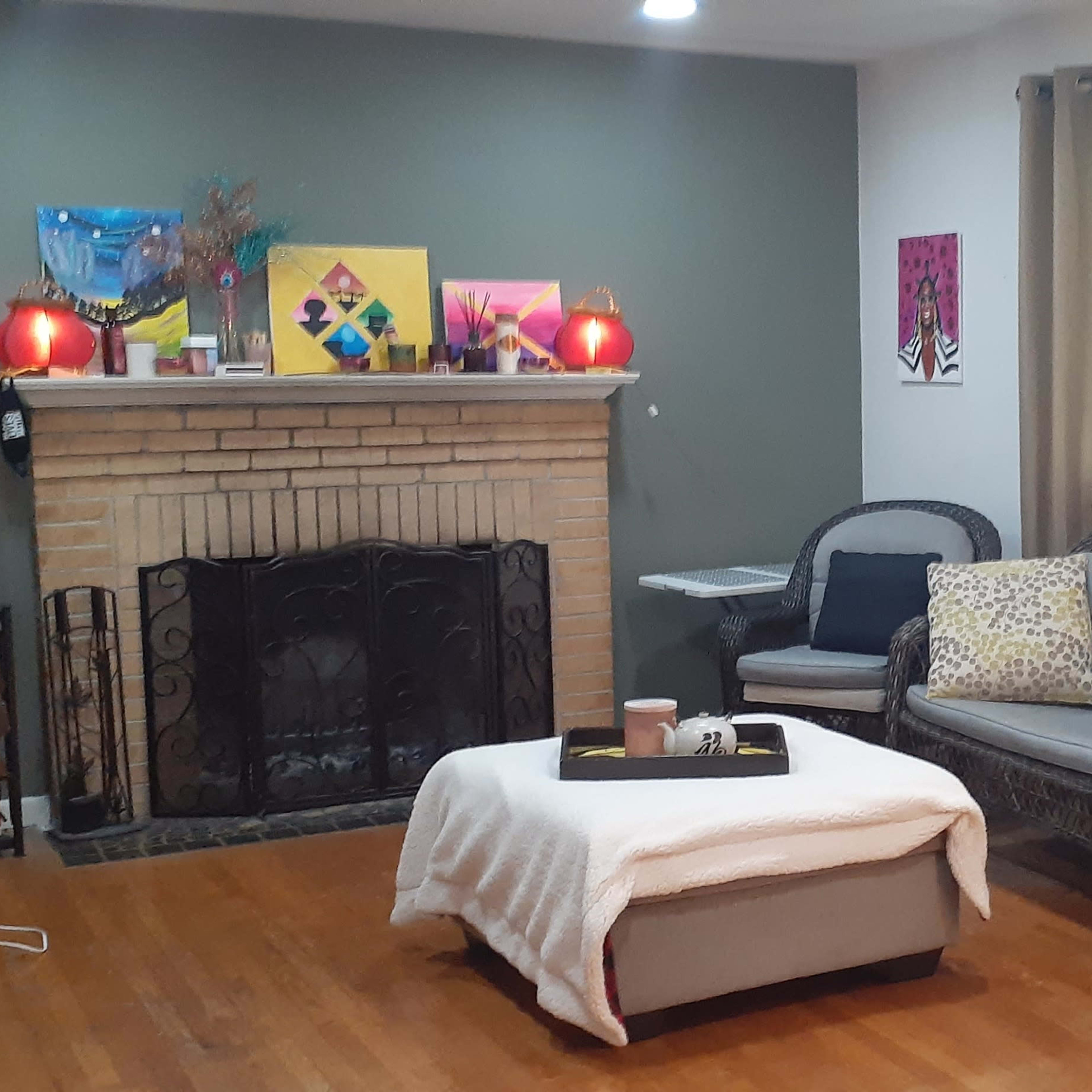 A living room with a fireplace, two couches, a coffee table, and artwork displayed on the walls.