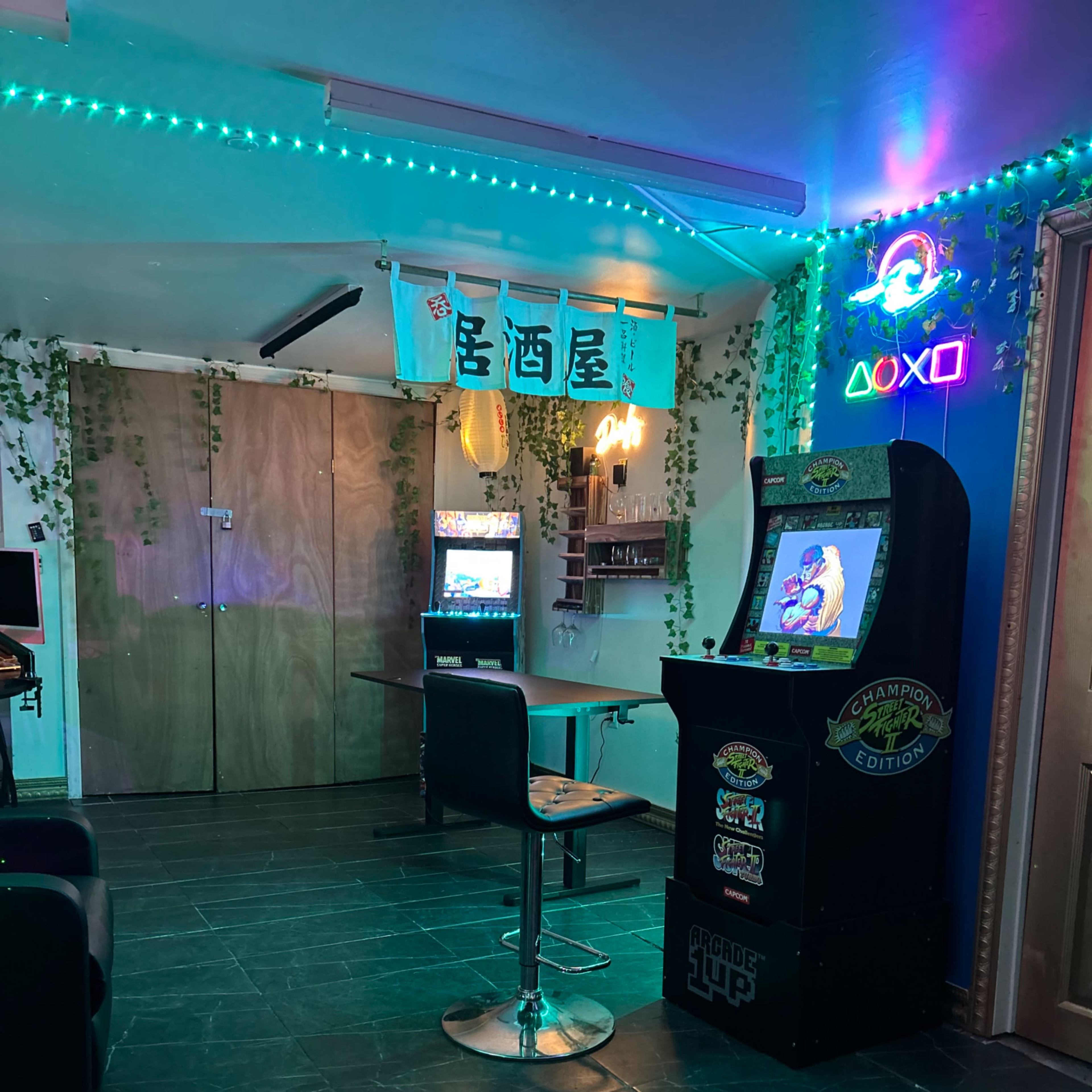 The scene features a retro arcade setup with a video game cabinet, a bar-style seating area, and neon lights amidst green decorative plants.
