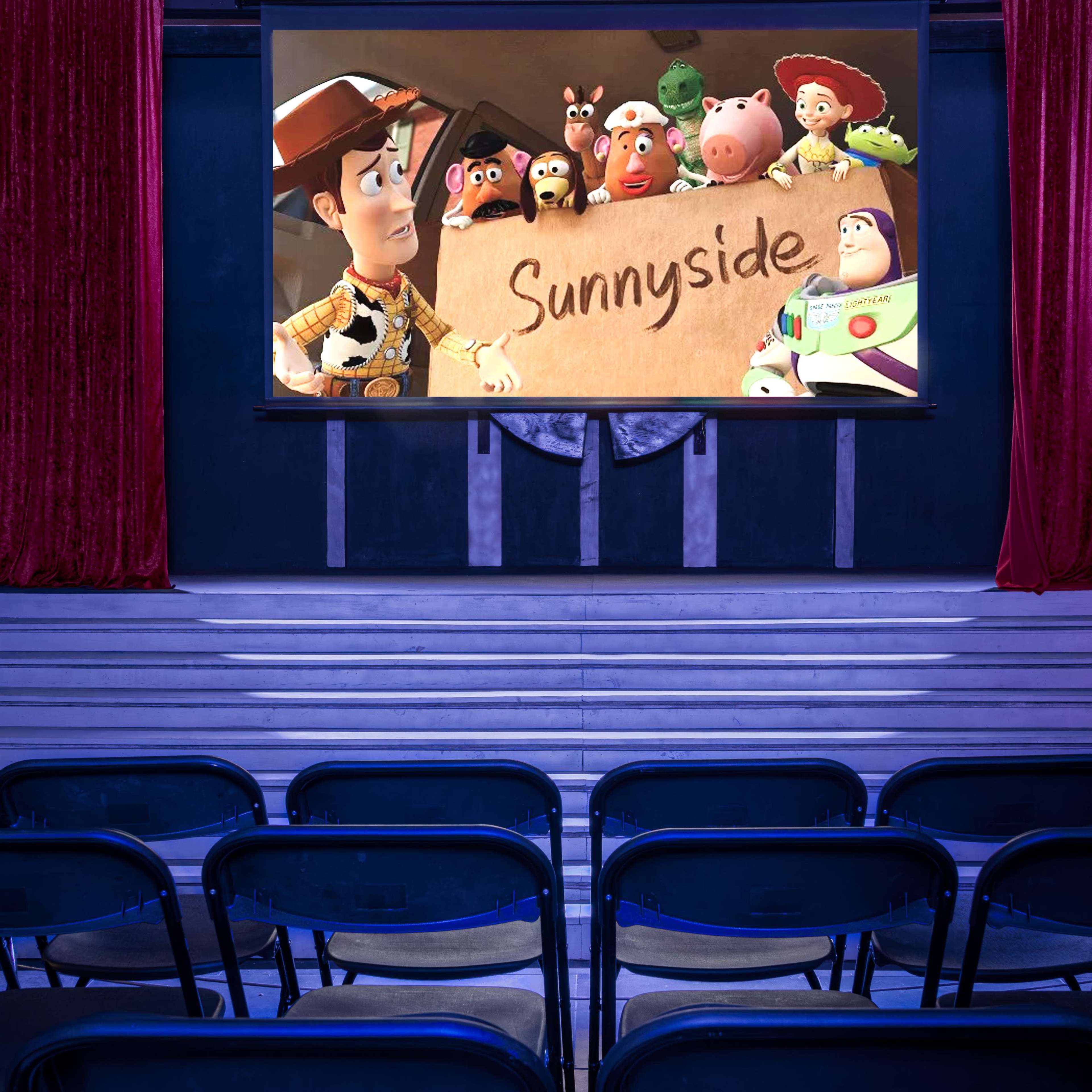 A movie theater features a large screen displaying animated characters in front of empty black chairs.