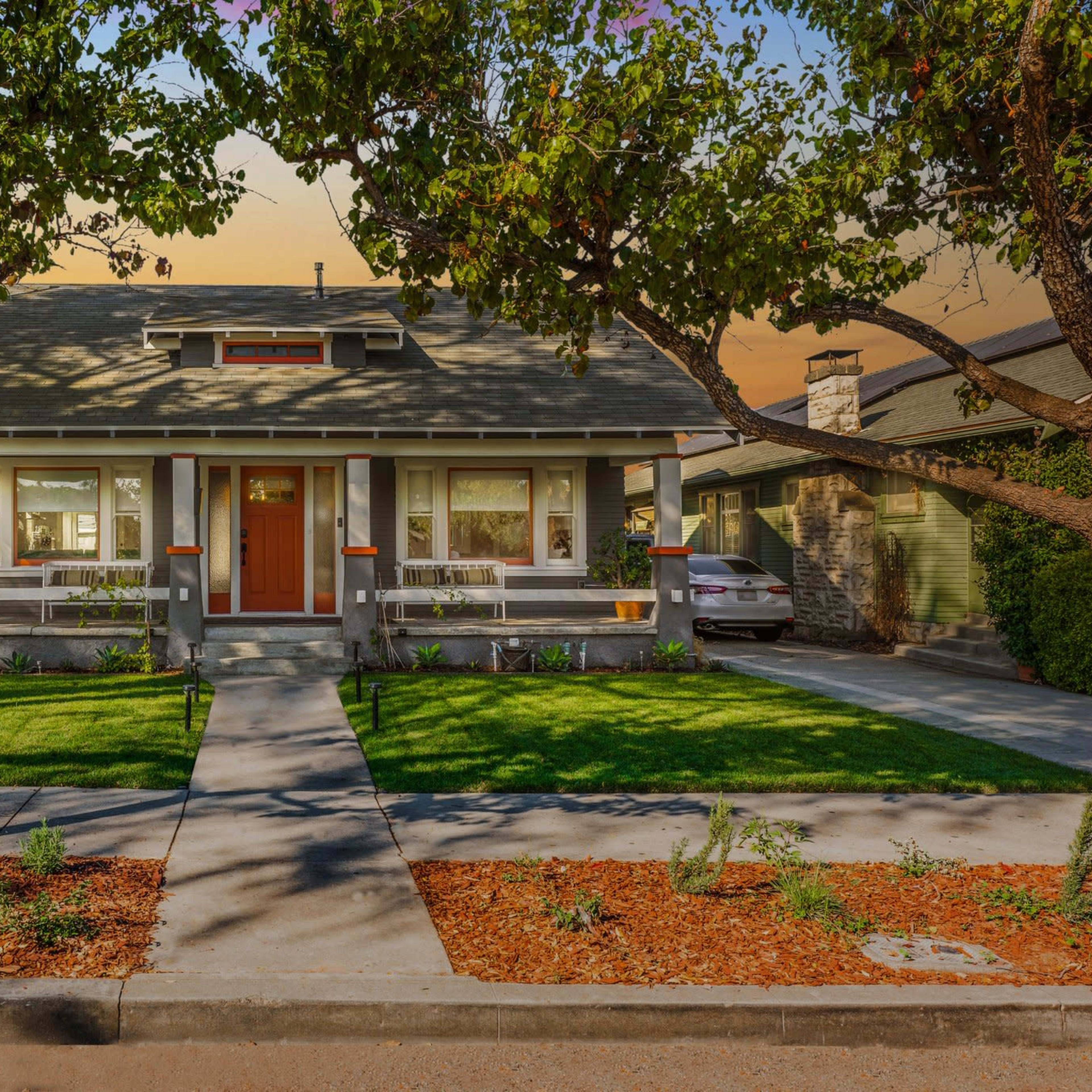 A two-story residential house with a landscaped front yard and a pathway leading to the entrance.