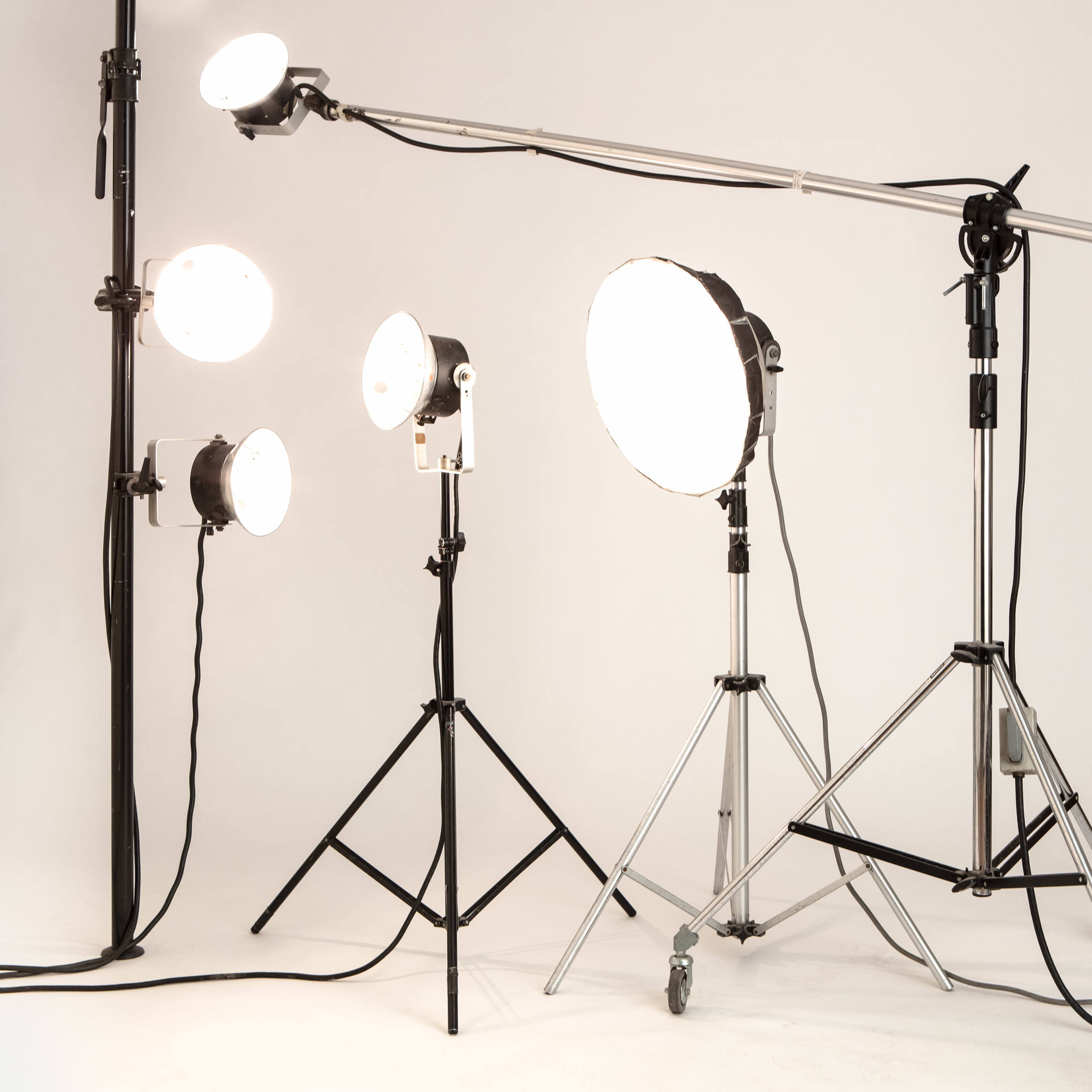 Various studio lights set up on stands against a plain background.