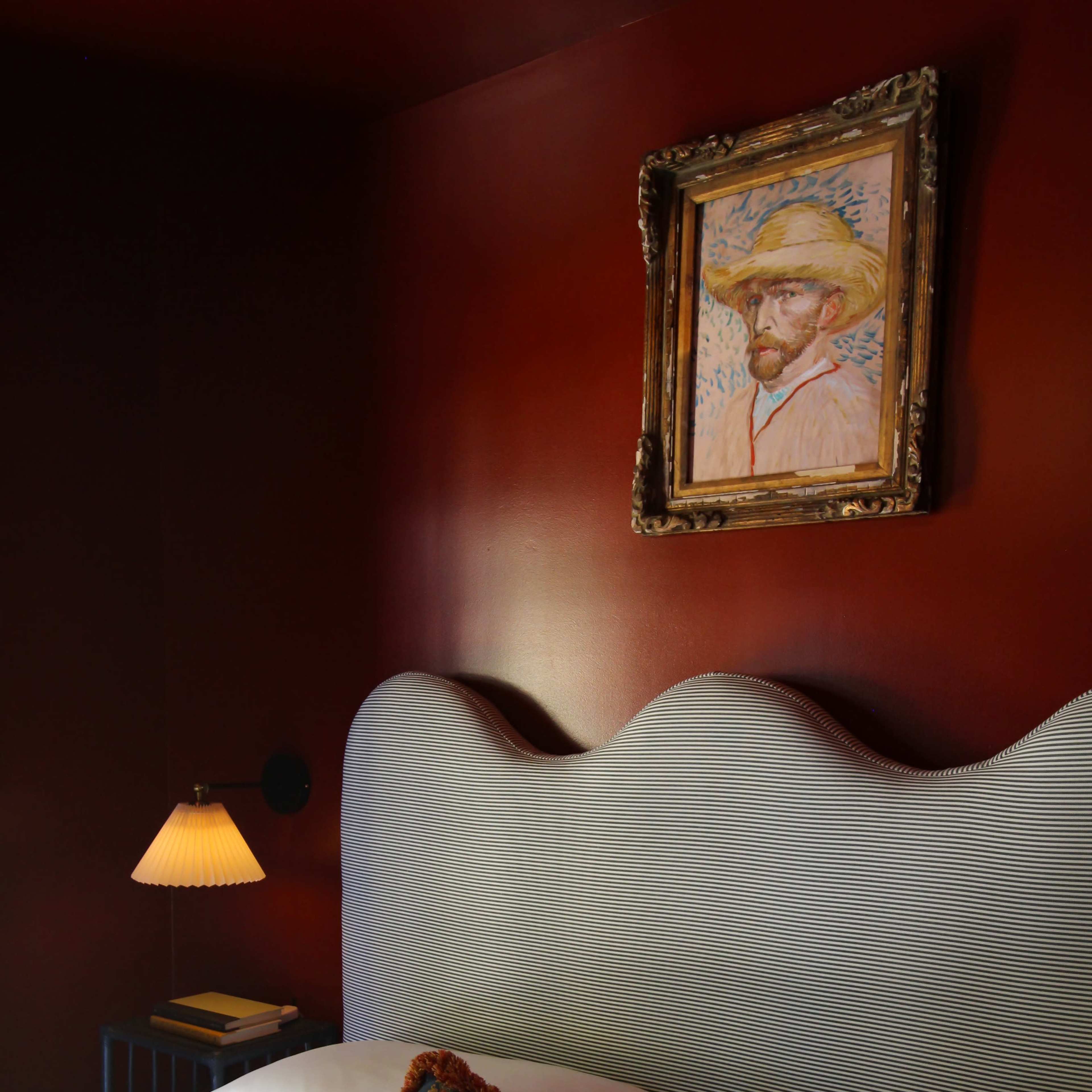 The living room features a light-colored sofa, a coffee table with books, a decorative mirror, and a large artwork on the wall, with floor-to-ceiling curtains and a fireplace.